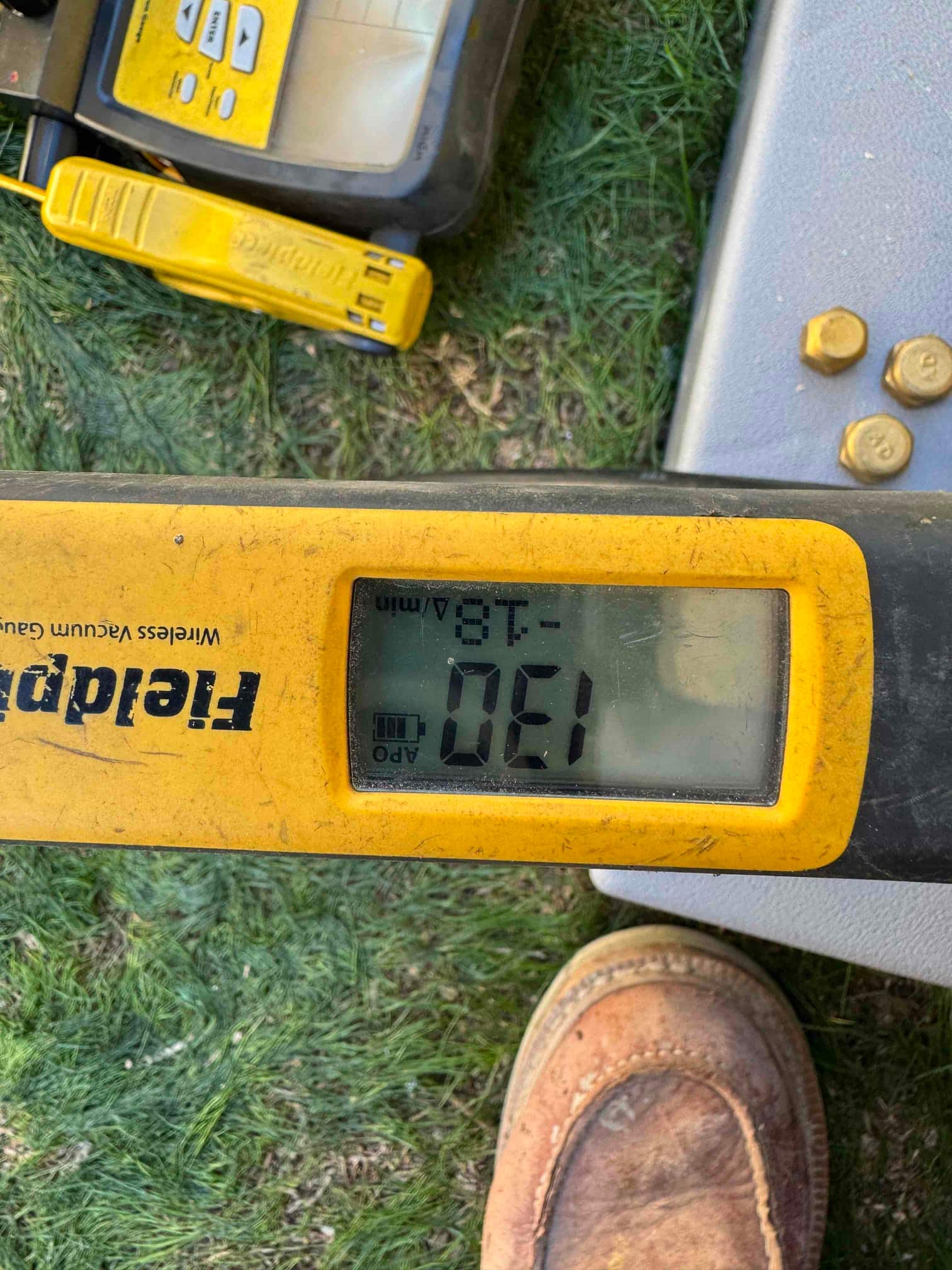 Digital micron gauge shows 130 microns during evacuation, confirming a deep vacuum on the newly installed system.