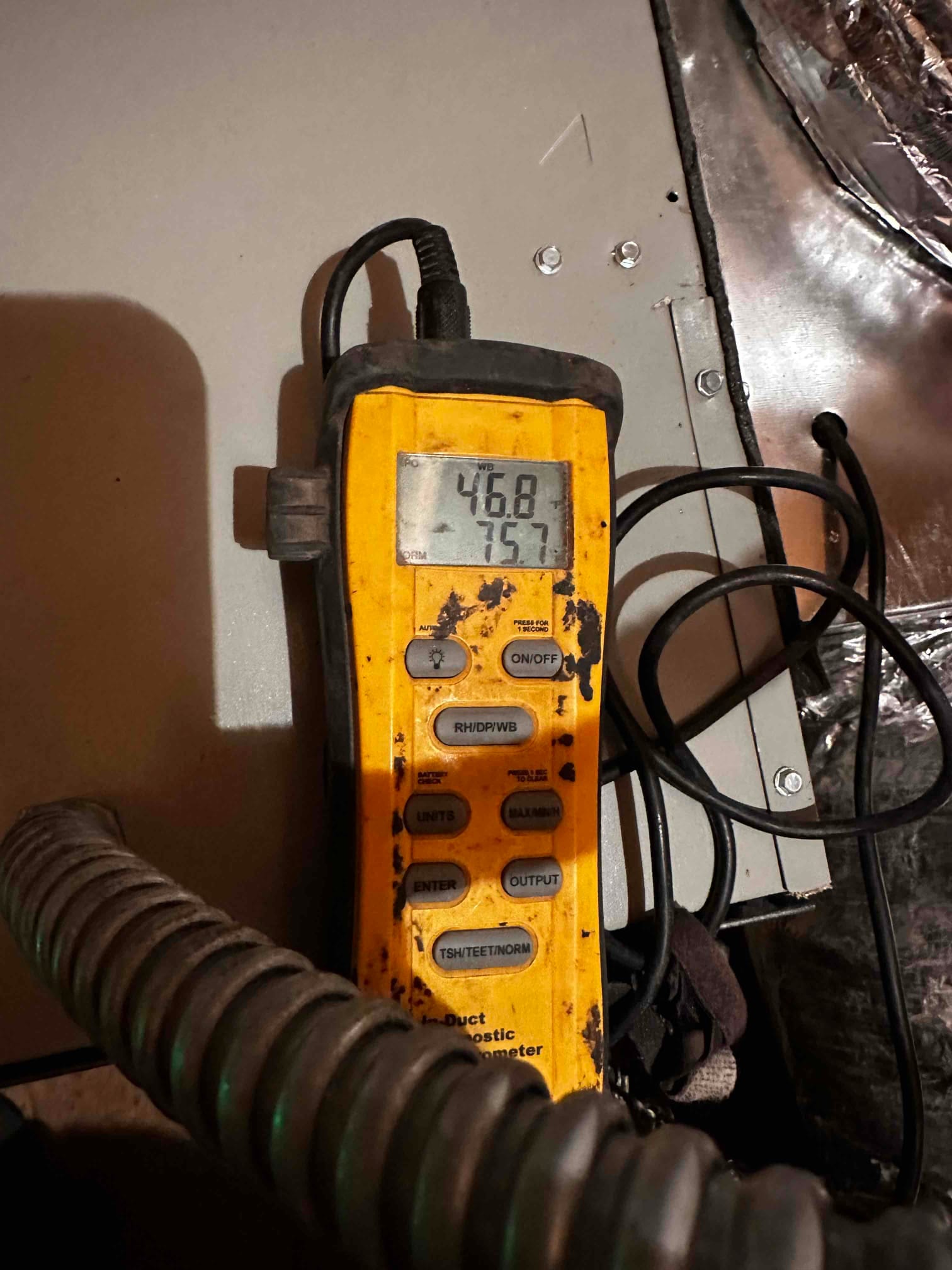 Digital thermometer at the air handler shows 46.8 degrees on the upper display during supply air temperature check.