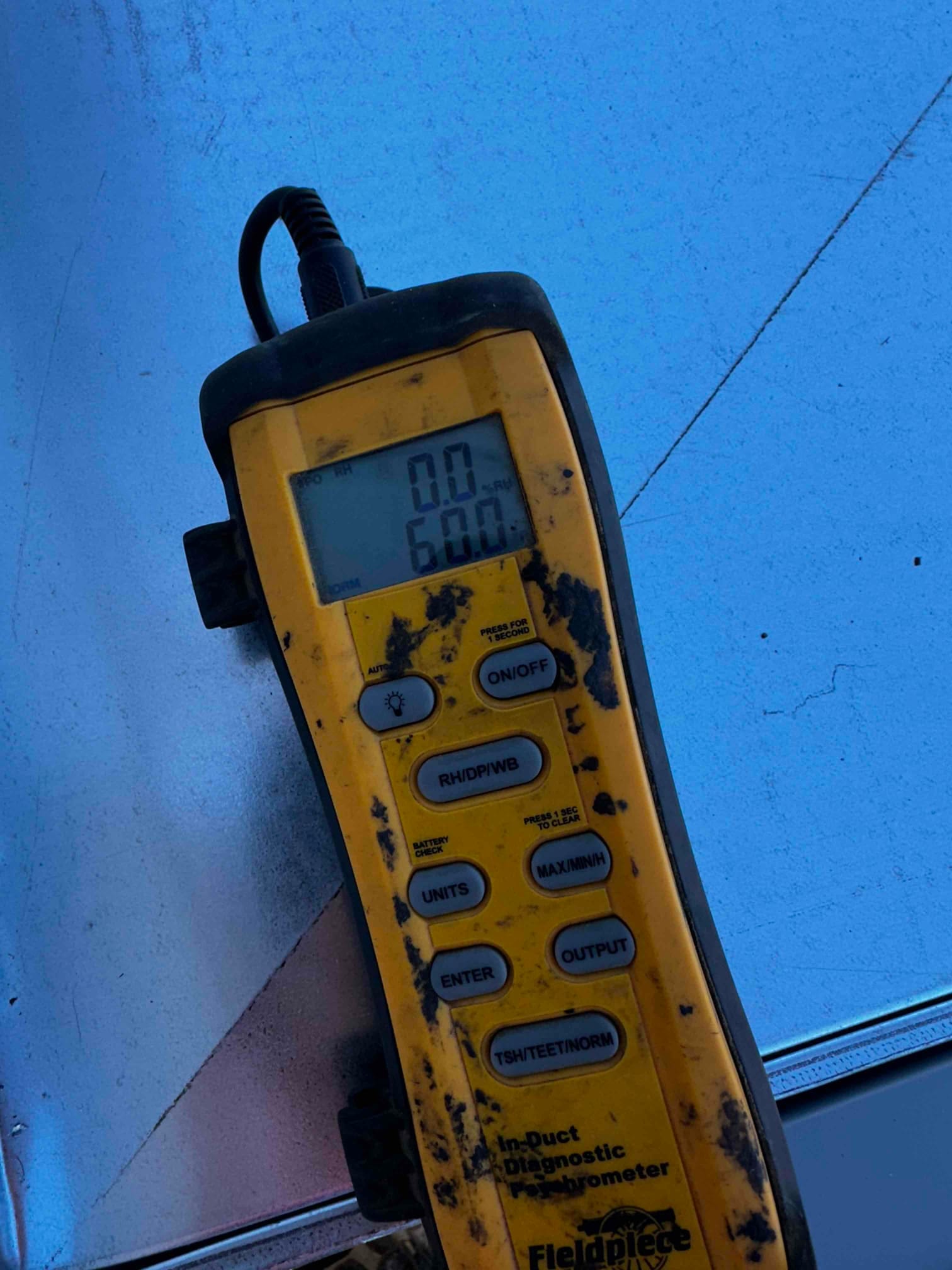 Digital thermometer displays 60.0 degrees Fahrenheit, documenting air temperature during system commissioning.