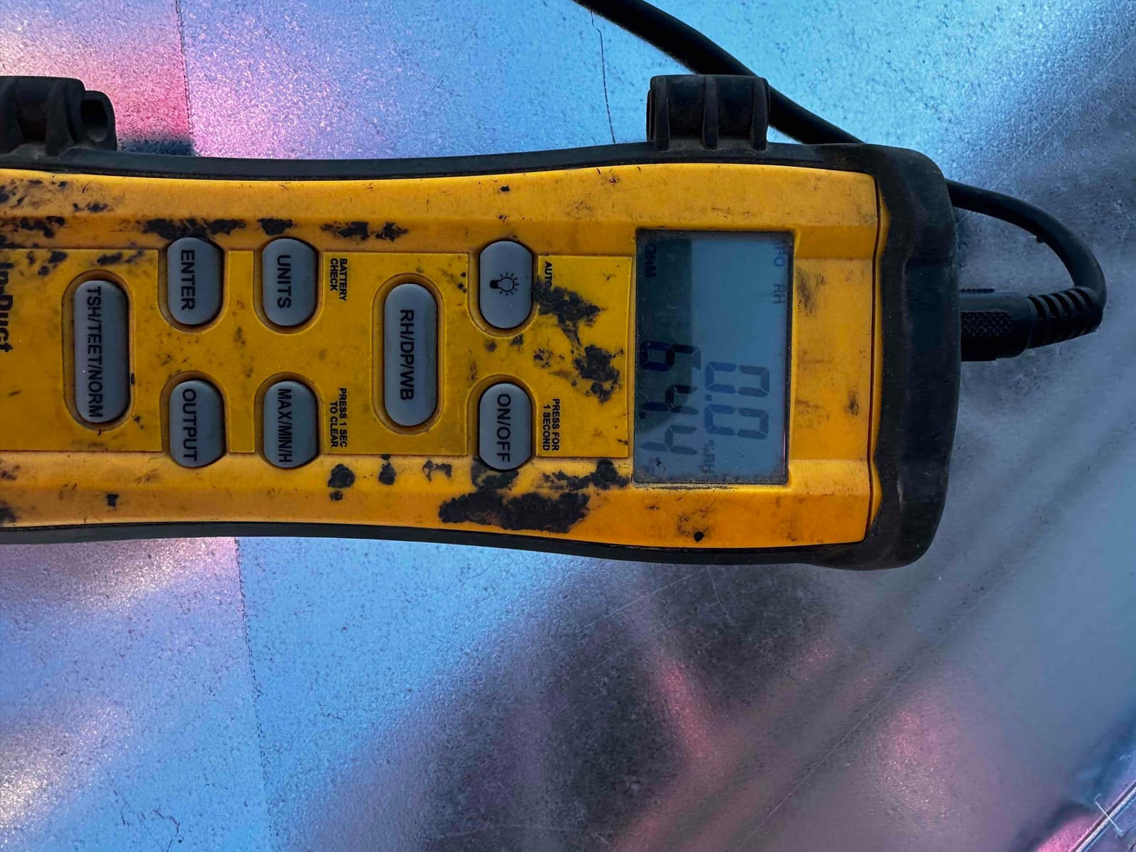 Digital thermometer on ductwork displays a temperature reading of 64.9°F during air-side commissioning.