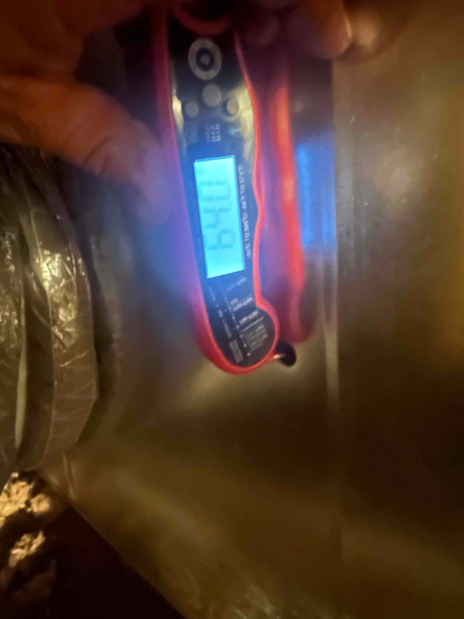 Digital thermometer inserted into metal duct reads 59°F, documenting supply air temperature leaving the evaporator.