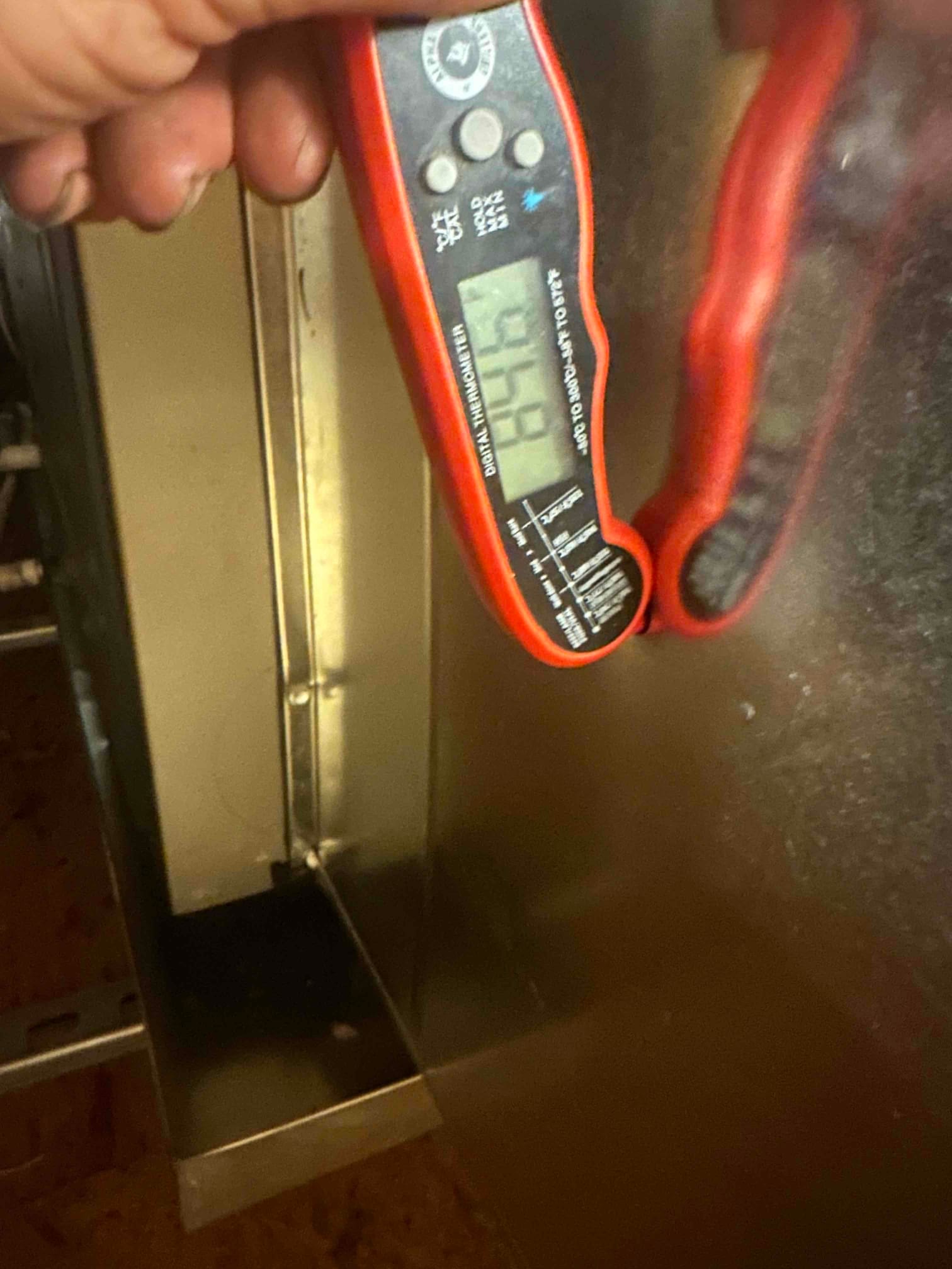 Digital thermometer reads 84°F at the return air location on the air handler cabinet during commissioning.