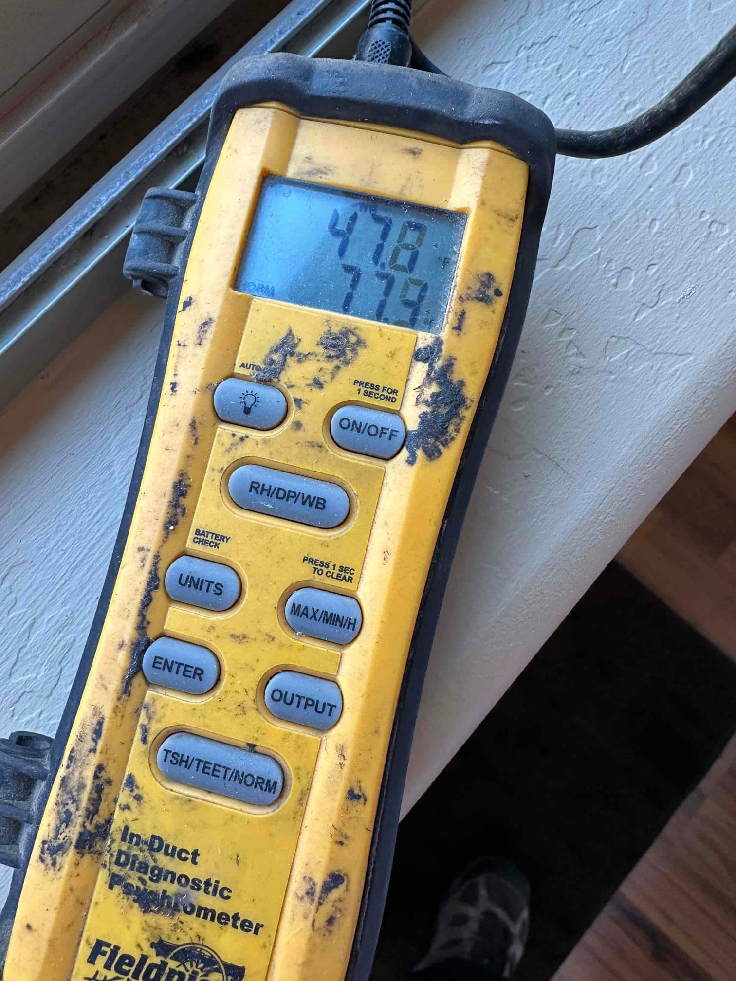 Digital thermometer shows 47.8°F and 77.9°F readings during air temperature checks at the HVAC system.