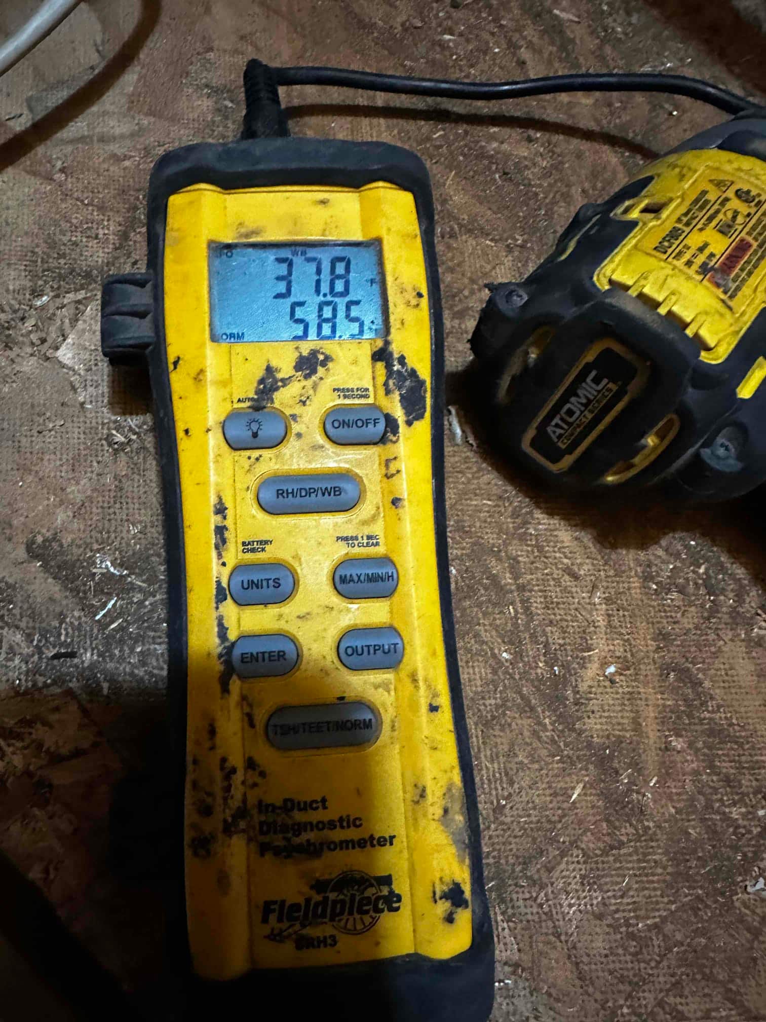 Digital thermometer shows 58.5°F air temperature during supply air check inside the duct following system startup.