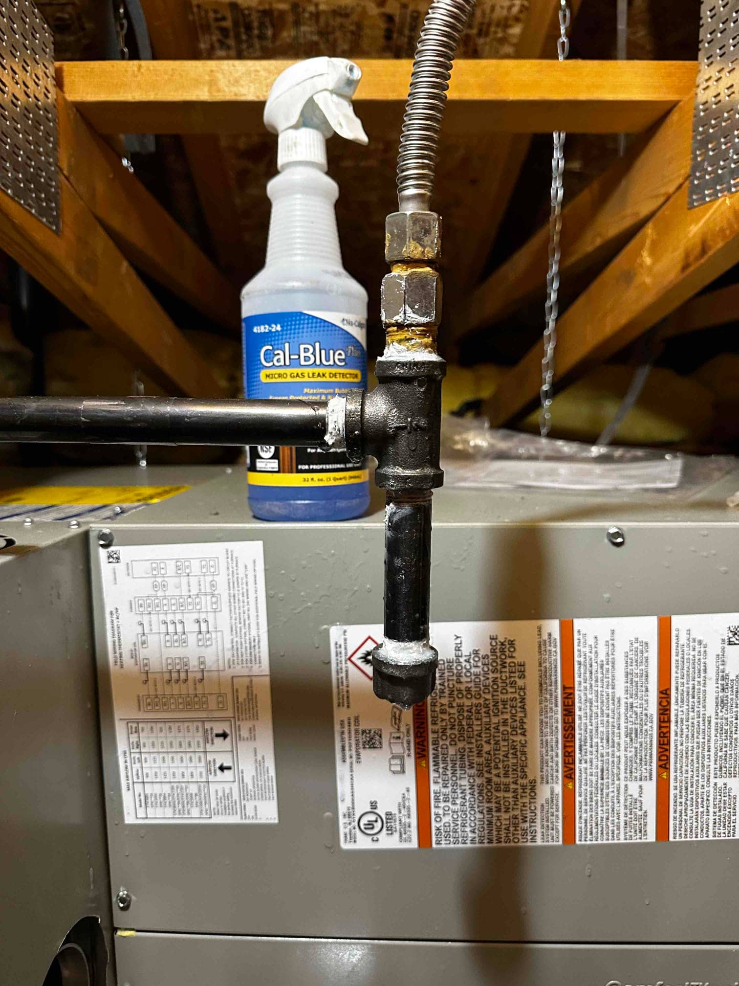 Gas flex connector with drip leg and shutoff installed at the furnace, with leak detector bottle nearby in the attic.