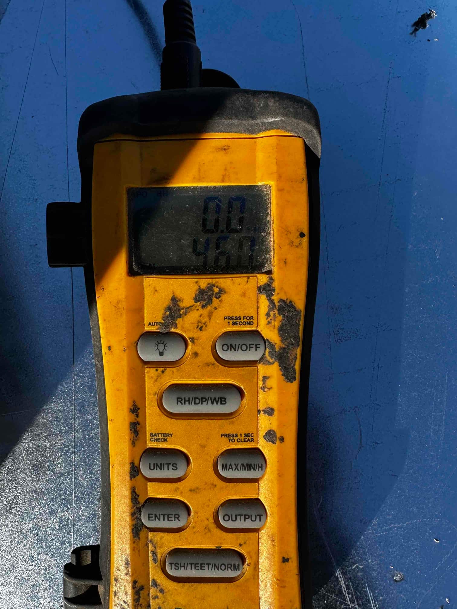 Handheld digital thermometer displays 46.7 degrees Fahrenheit during air-side commissioning of the newly installed system.