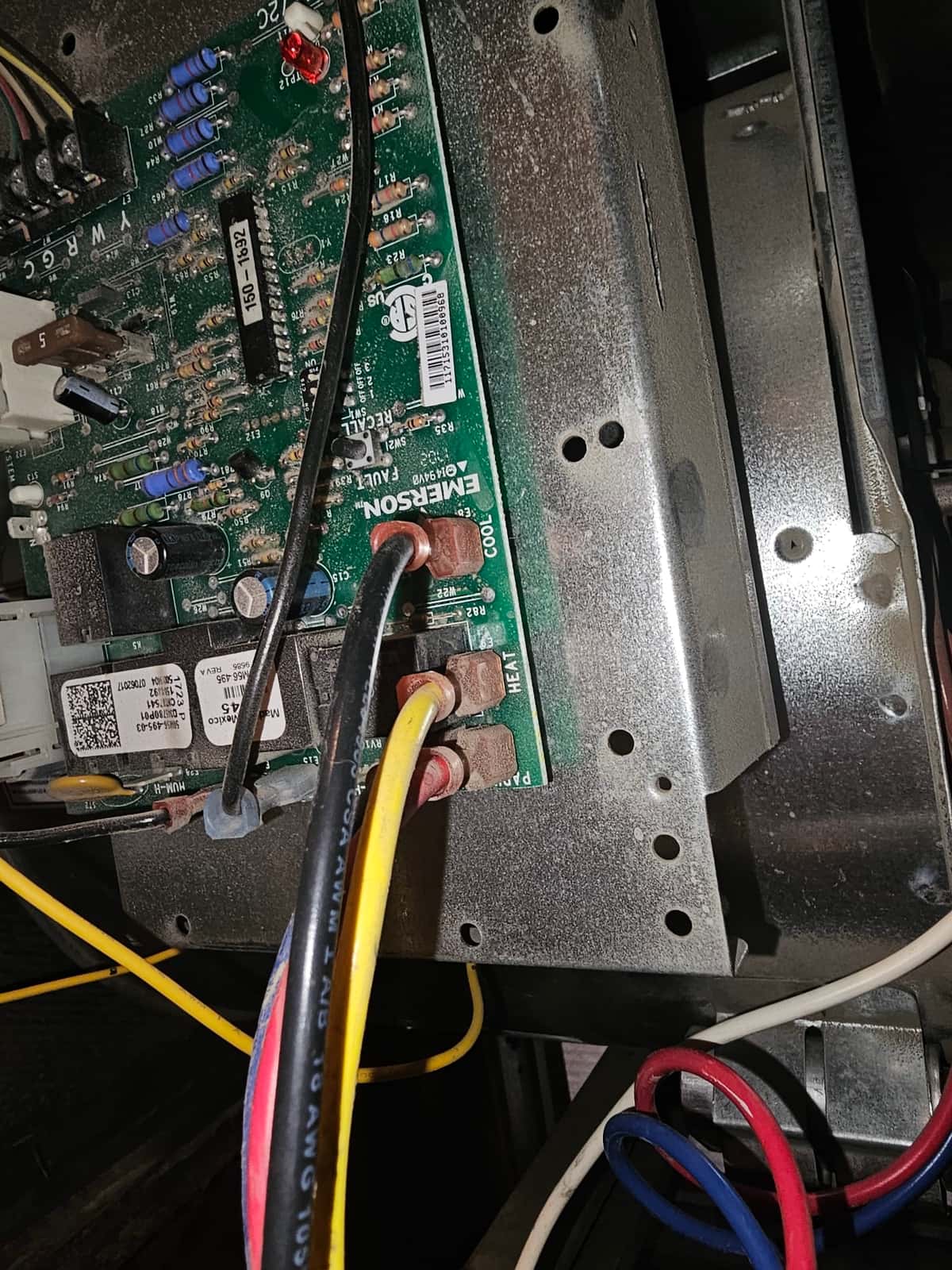 HVAC control board showing COOL and HEAT screw terminals with attached wires, discrete components, and a 5-amp blade fuse.