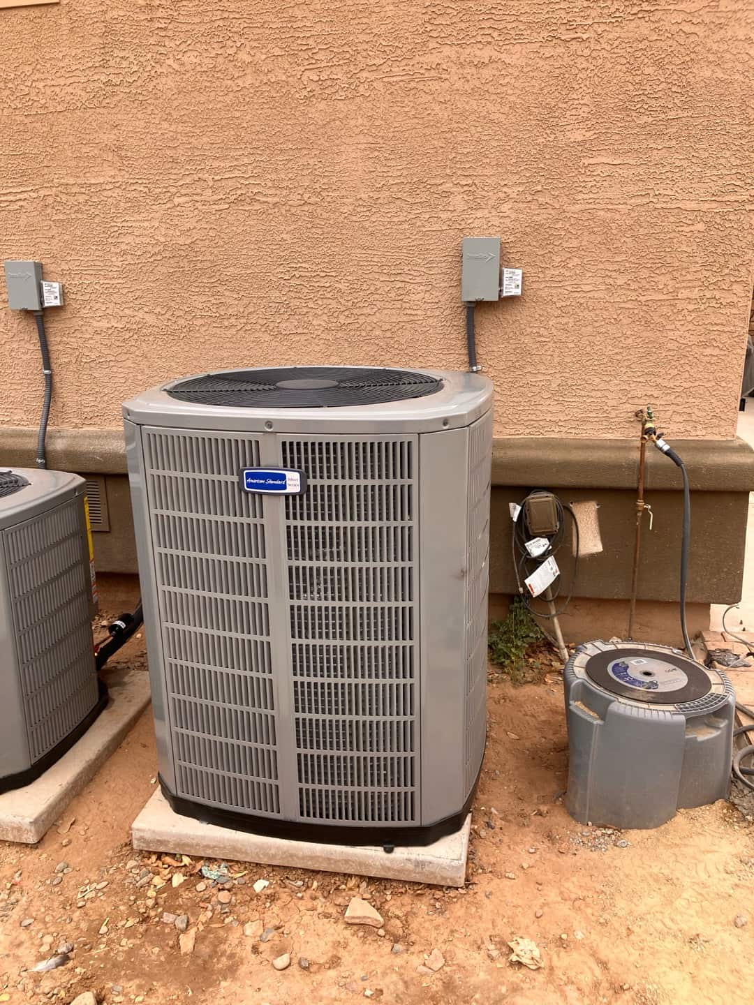 New outdoor condensers set on level pads with weatherproof disconnects and insulated line sets at the exterior wall.