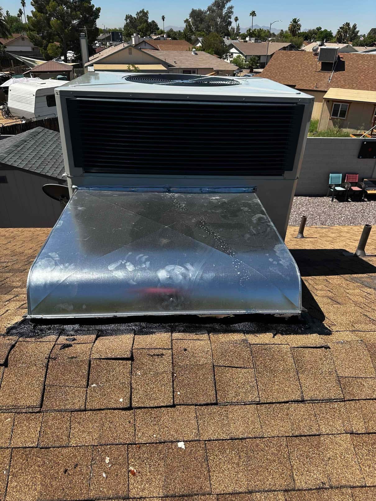 Package HVAC unit mounted on roof with new galvanized supply plenum and sealed roof penetration visible.