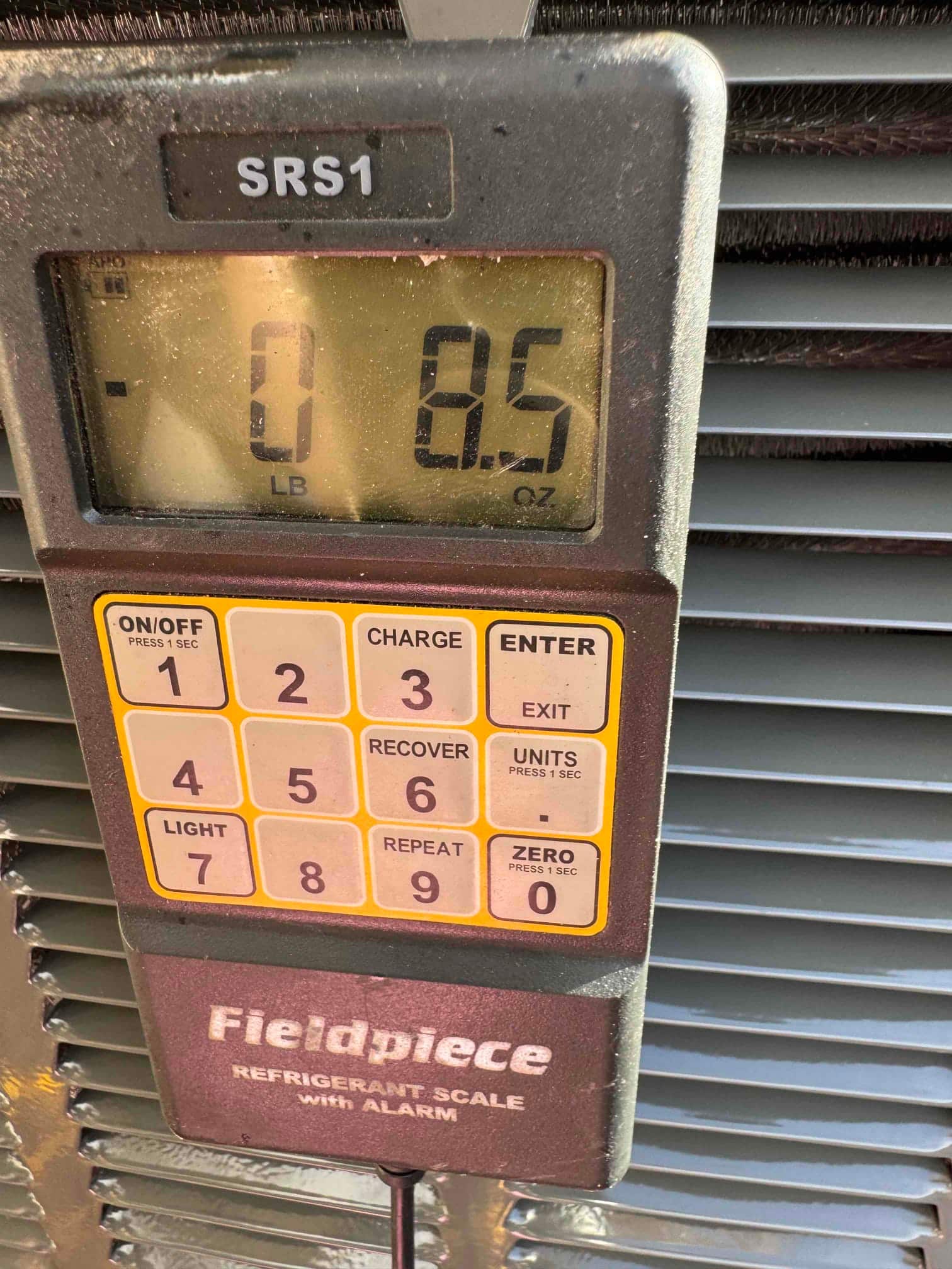 Refrigerant charging scale display shows 0 pounds 8.5 ounces during charging of the newly installed system.