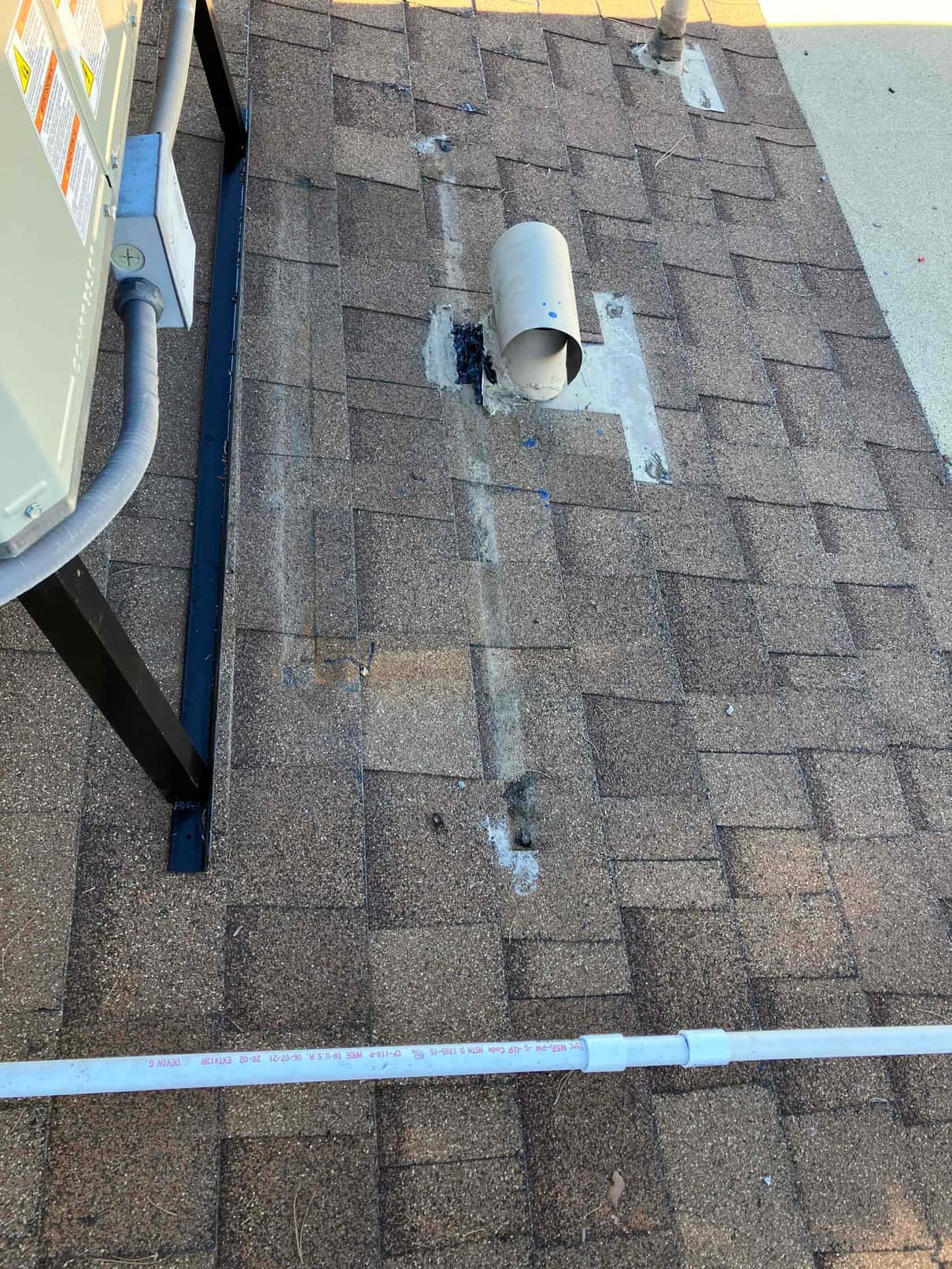 Rooftop installation details showing conduit, roof penetration with vent hood, and routed condensate drain line beside the unit stand.