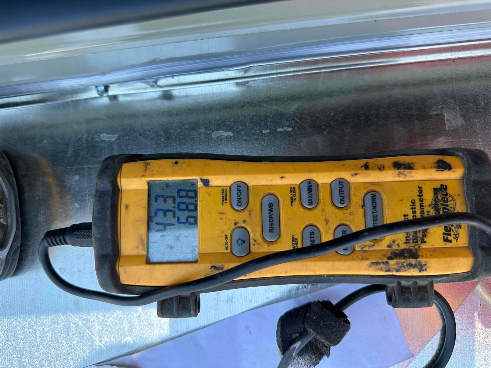 Digital thermometer shows 68.8°F during air temperature check on the newly installed system.