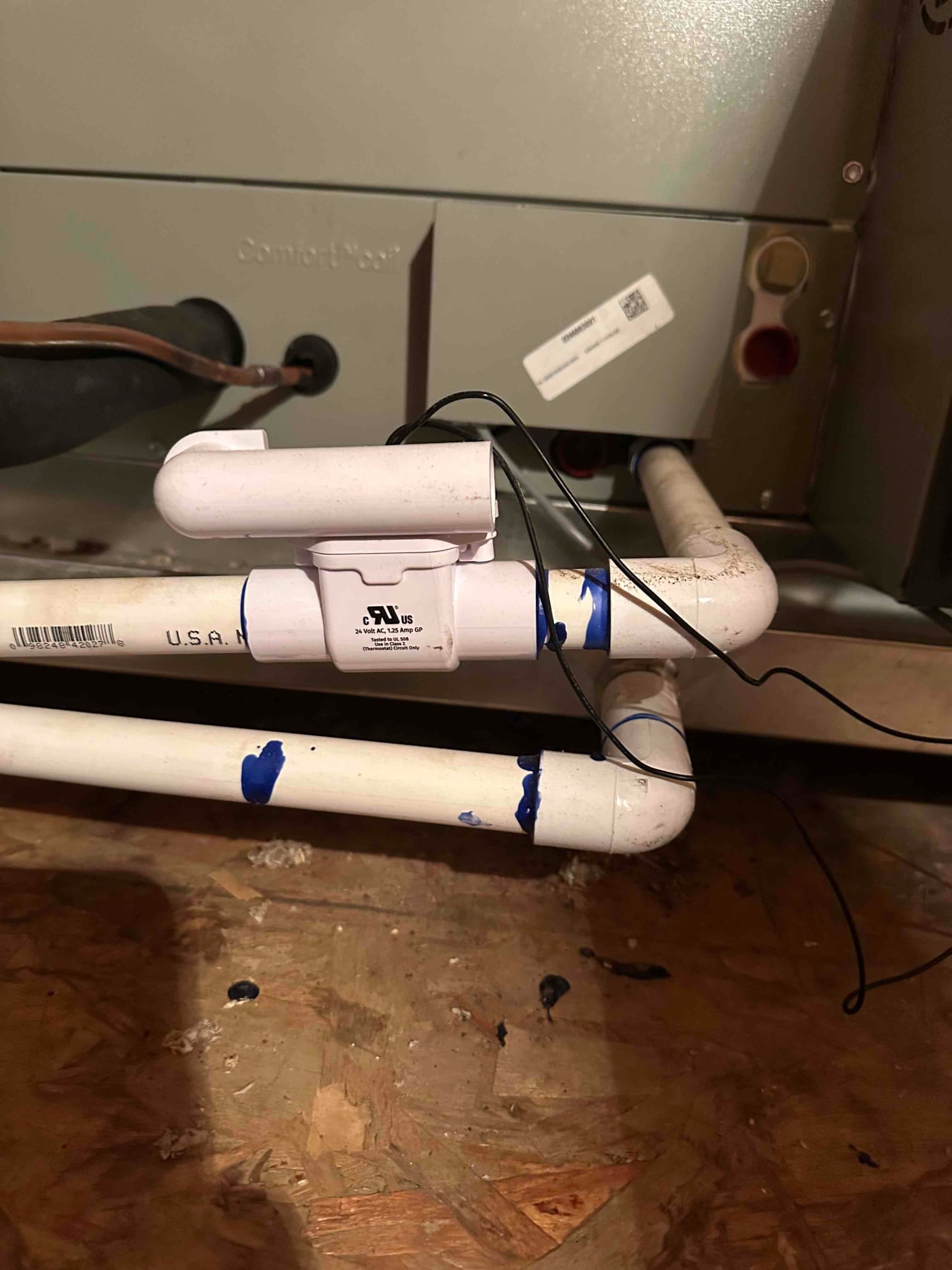 Condensate drain assembly with cleanout and trap installed at the air handler, with wiring routed alongside the PVC lines.