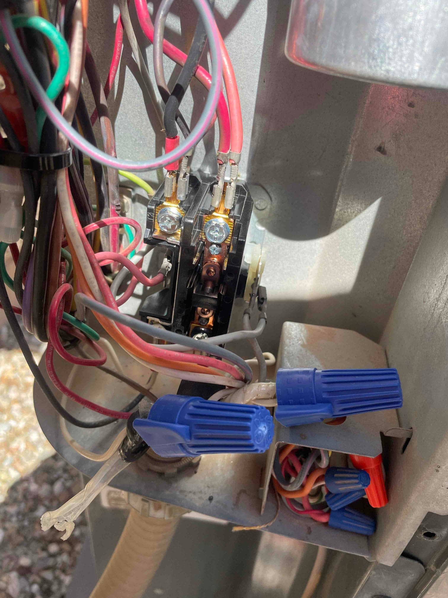 Contactor inside outdoor unit shows connected red and black wires, with multiple wire-nut splices in the control compartment.
