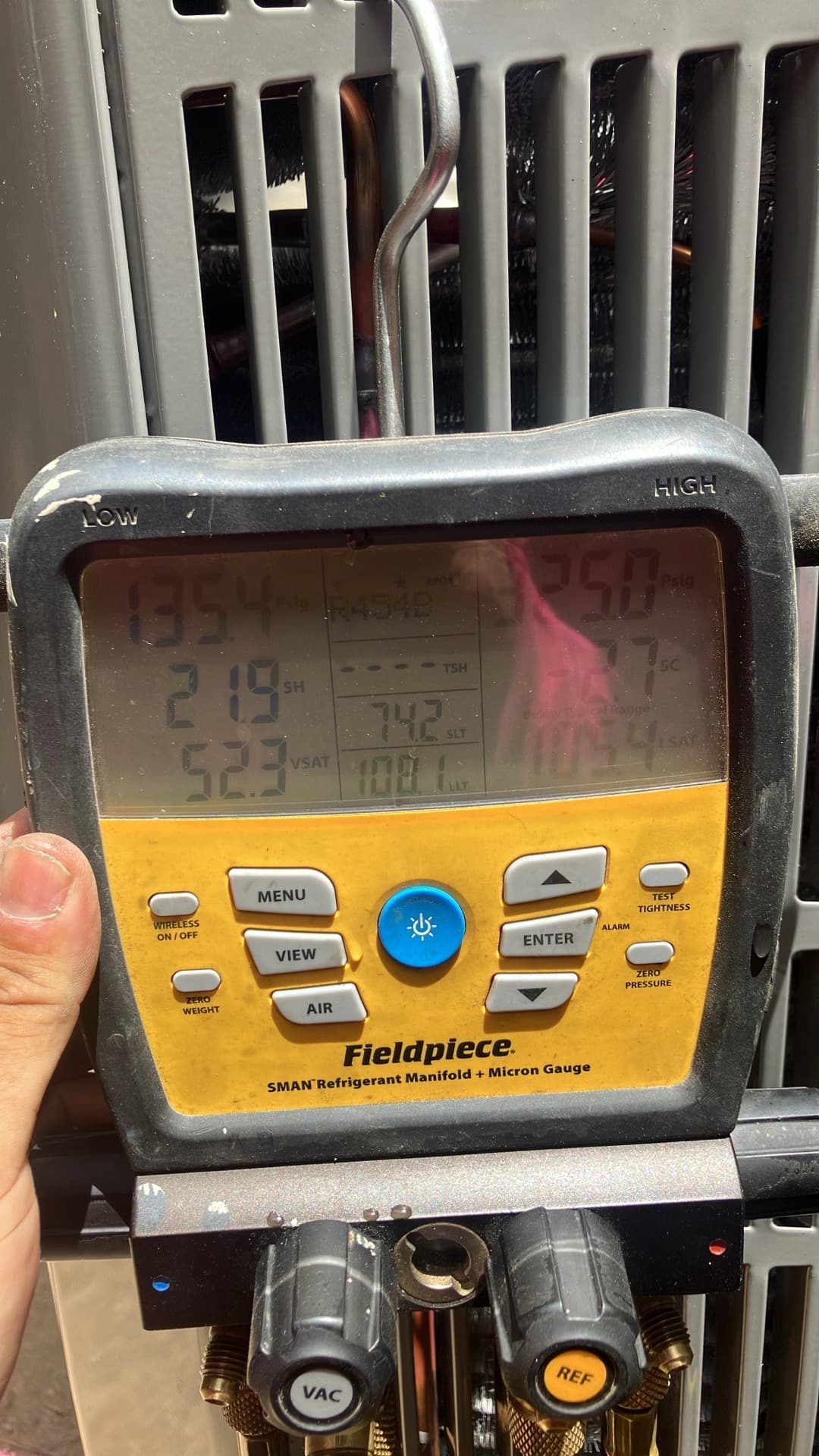 Digital manifold attached to the outdoor unit displays operating pressures and temperatures during system commissioning.