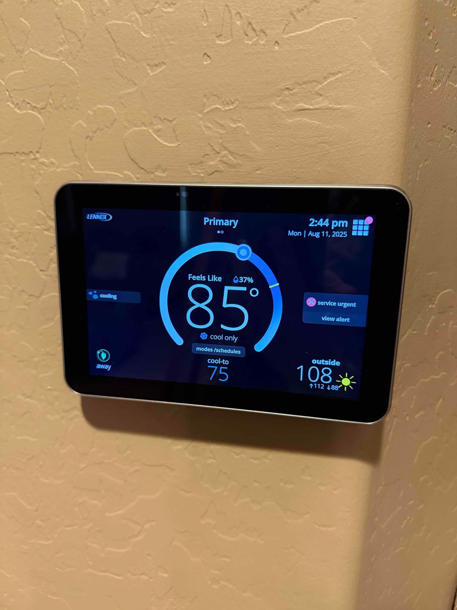 Wall-mounted smart thermostat displays indoor temperature at 85°F with cooling setpoint 75°F and outside temperature 108°F.