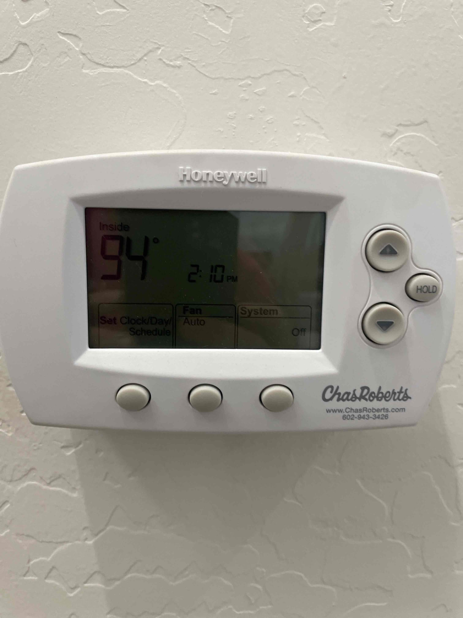 Wall-mounted thermostat shows inside 94°, time 2:10 PM, fan set to Auto, system set to Off.