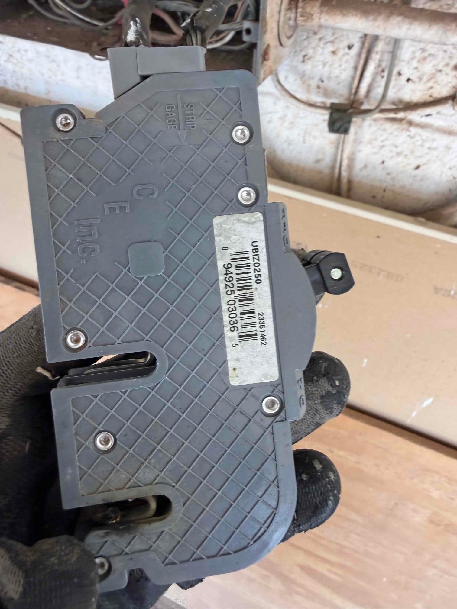 Close-up of an electrical component removed during the HVAC installation, showing wiring entry points and mounting screws.