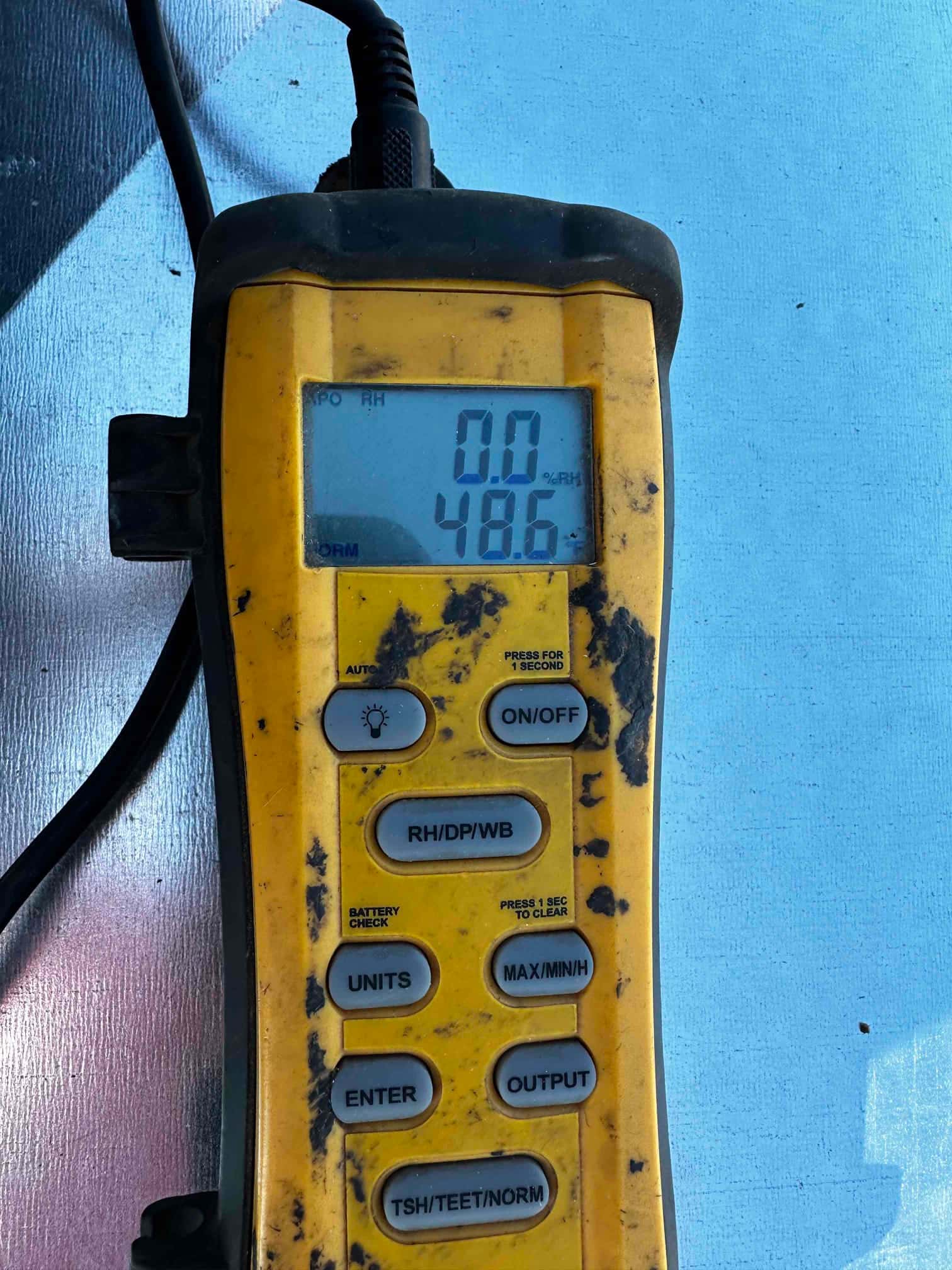 Digital thermometer displays 48.6 degrees Fahrenheit during air-side checks on the newly installed system.