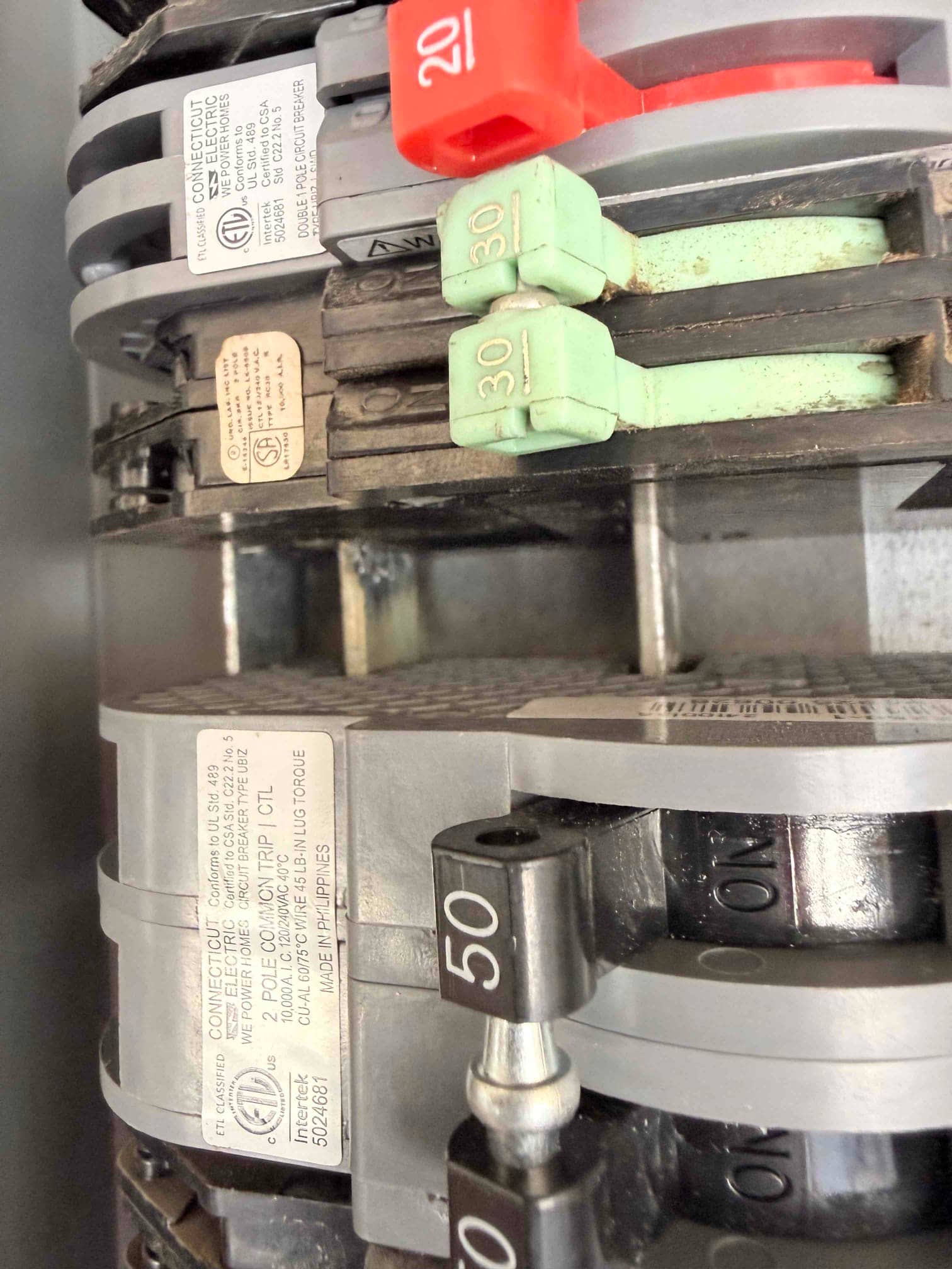 Electrical panel with multiple breakers labeled 20, 30, and 50 amps in the ON position for HVAC circuits.