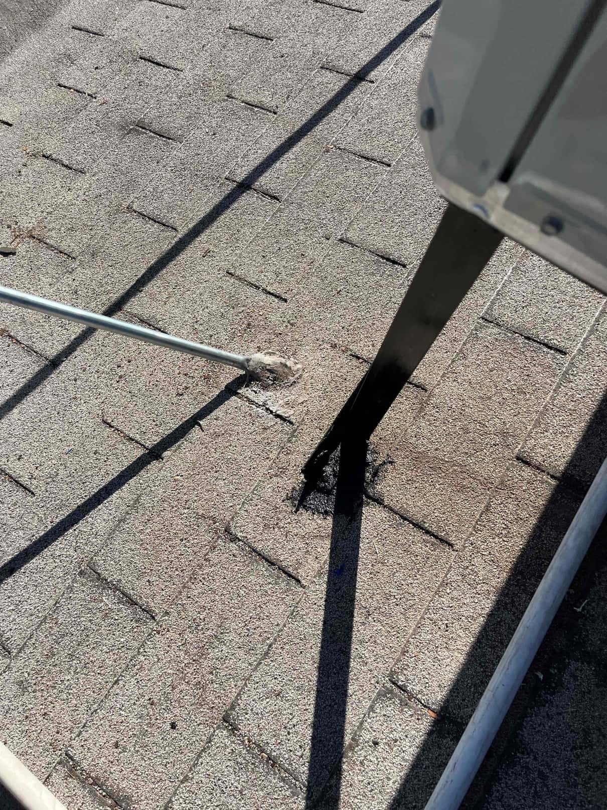 Sealed roof penetration with mounting leg and conduit adjacent, showing weatherproofing around new rooftop HVAC installation components.