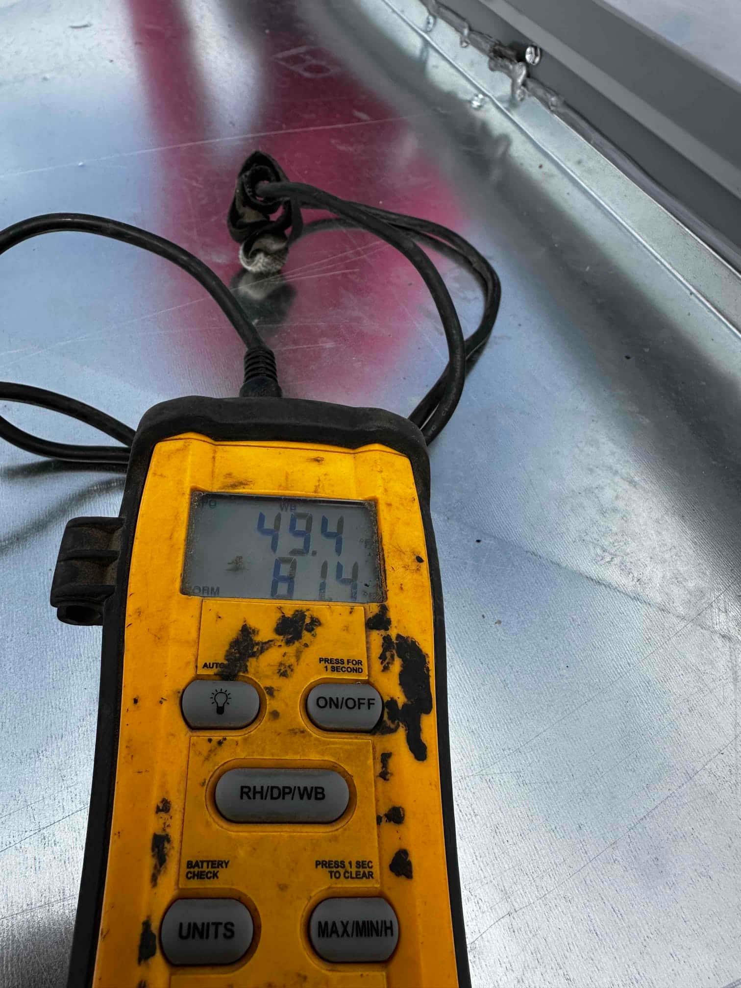 Digital thermometer on the duct shows air temperature readings of 49.4°F and 81.4°F during commissioning checks.