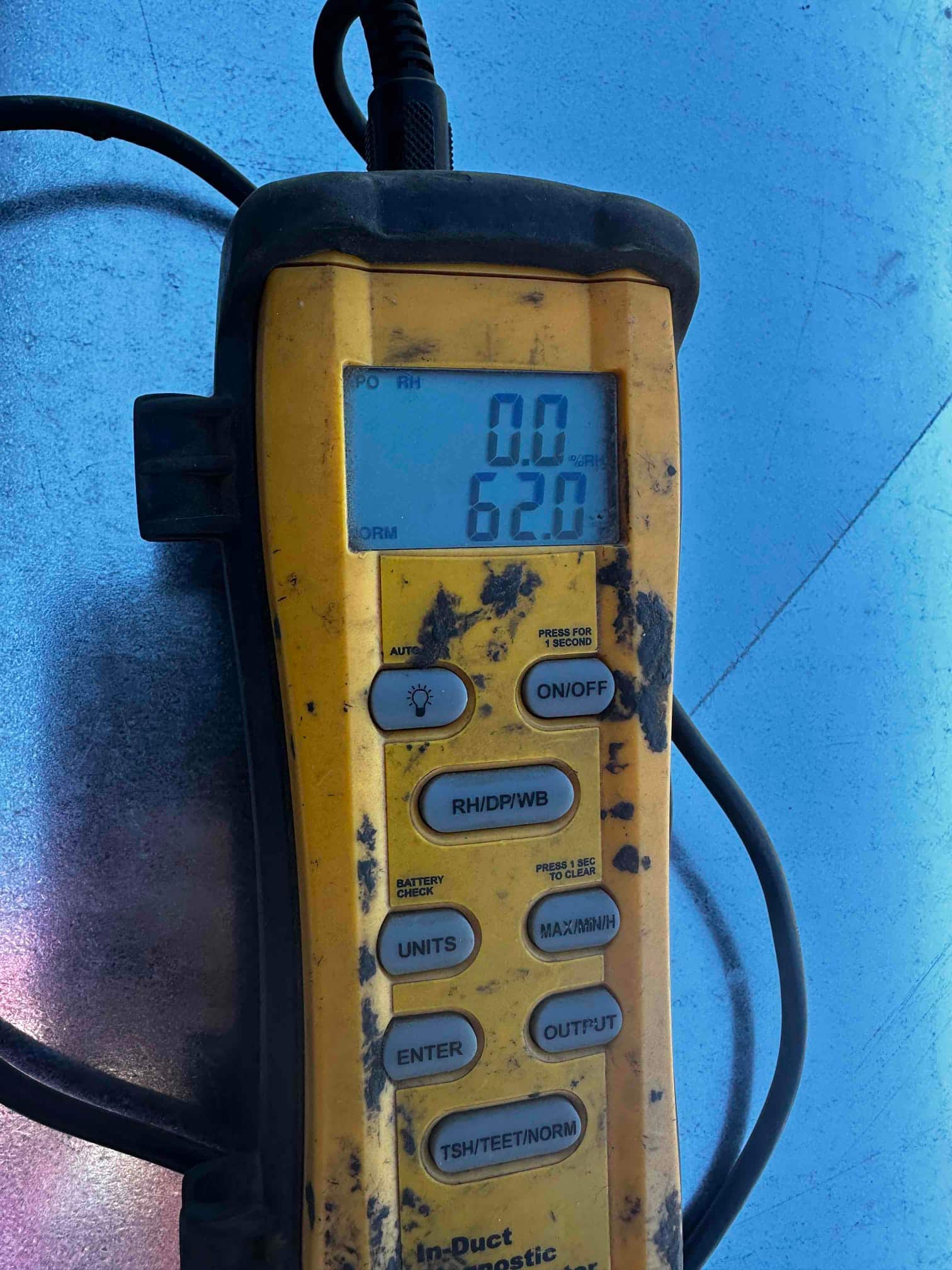 Digital thermometer shows 62.0 degrees, documenting an air temperature measurement during HVAC commissioning.