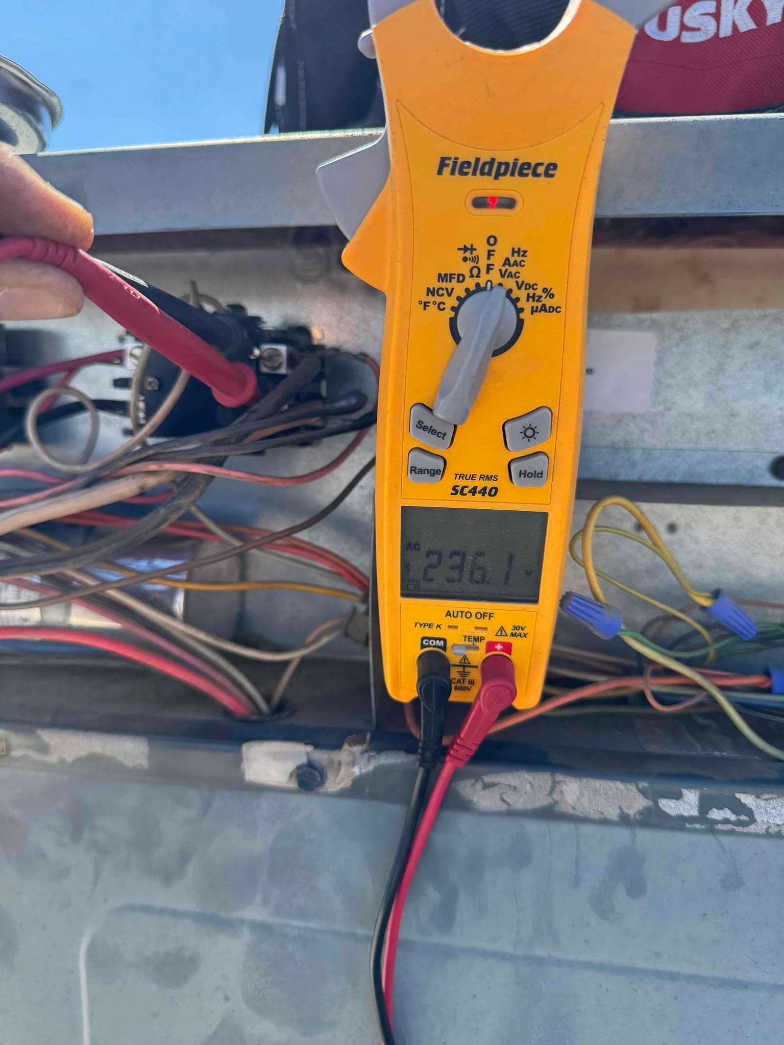 Digital multimeter shows 236.1 V across the contactor terminals during air conditioner service.
