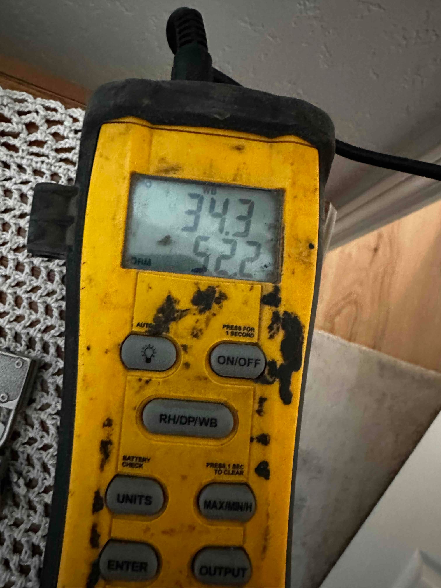 Digital thermometer displays 52.2 degrees, documenting cool supply air temperature during system commissioning.