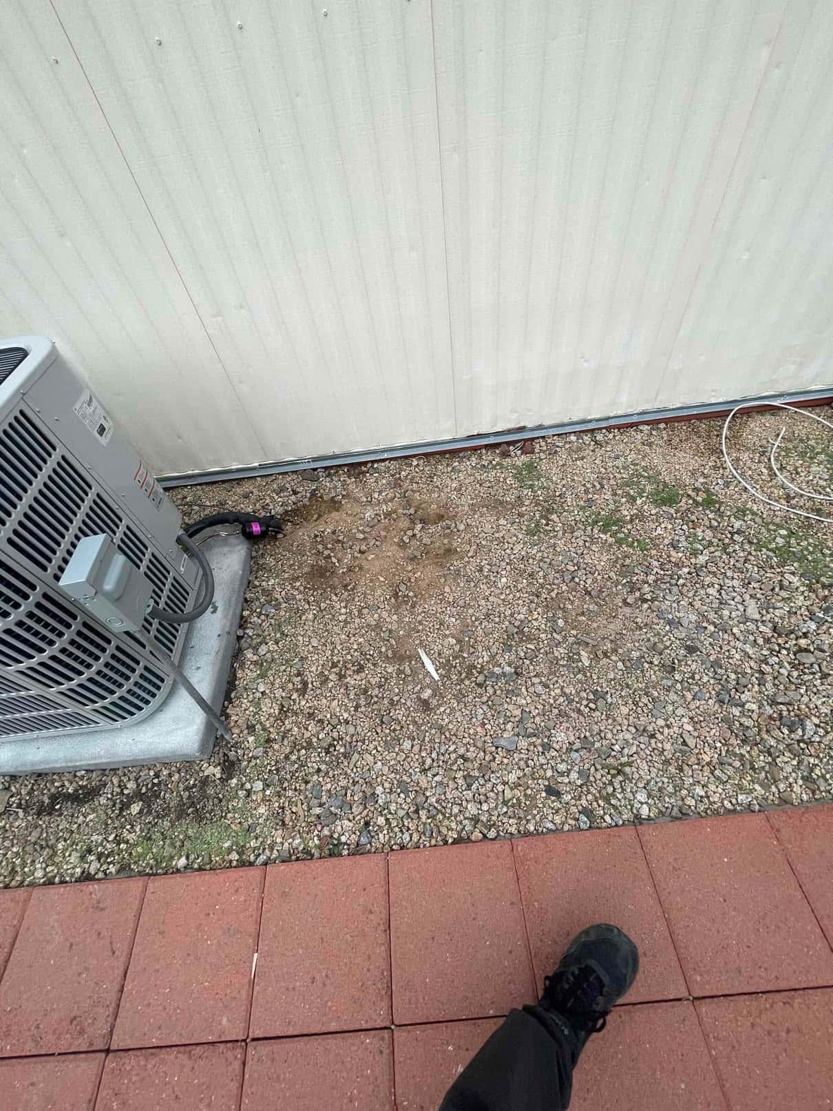 New outdoor condenser set on a level pad with insulated refrigerant lines routed along the exterior wall.