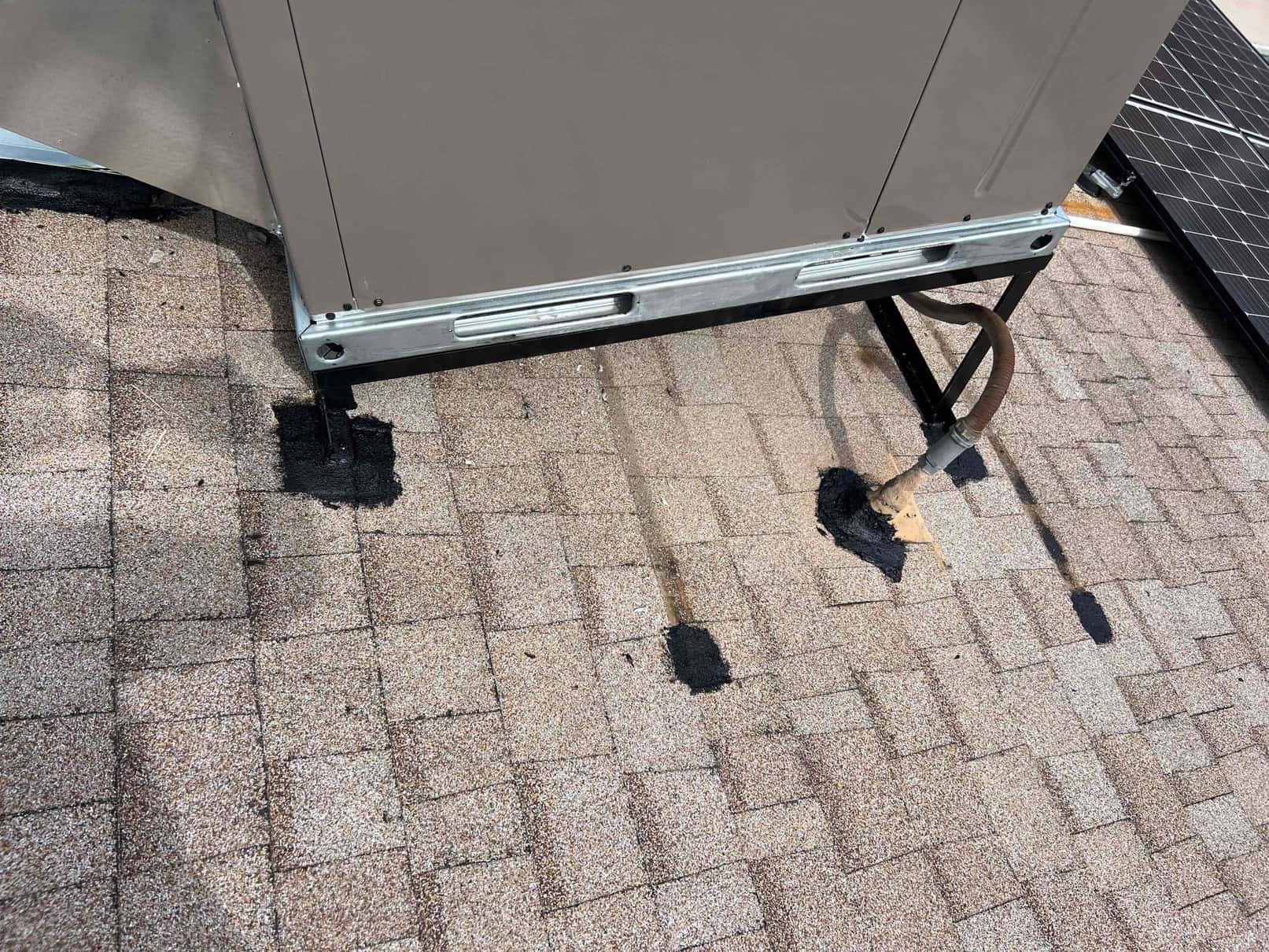 Rooftop package unit set on a metal stand with sealed roof penetrations and insulated refrigerant lines routed into the roof.