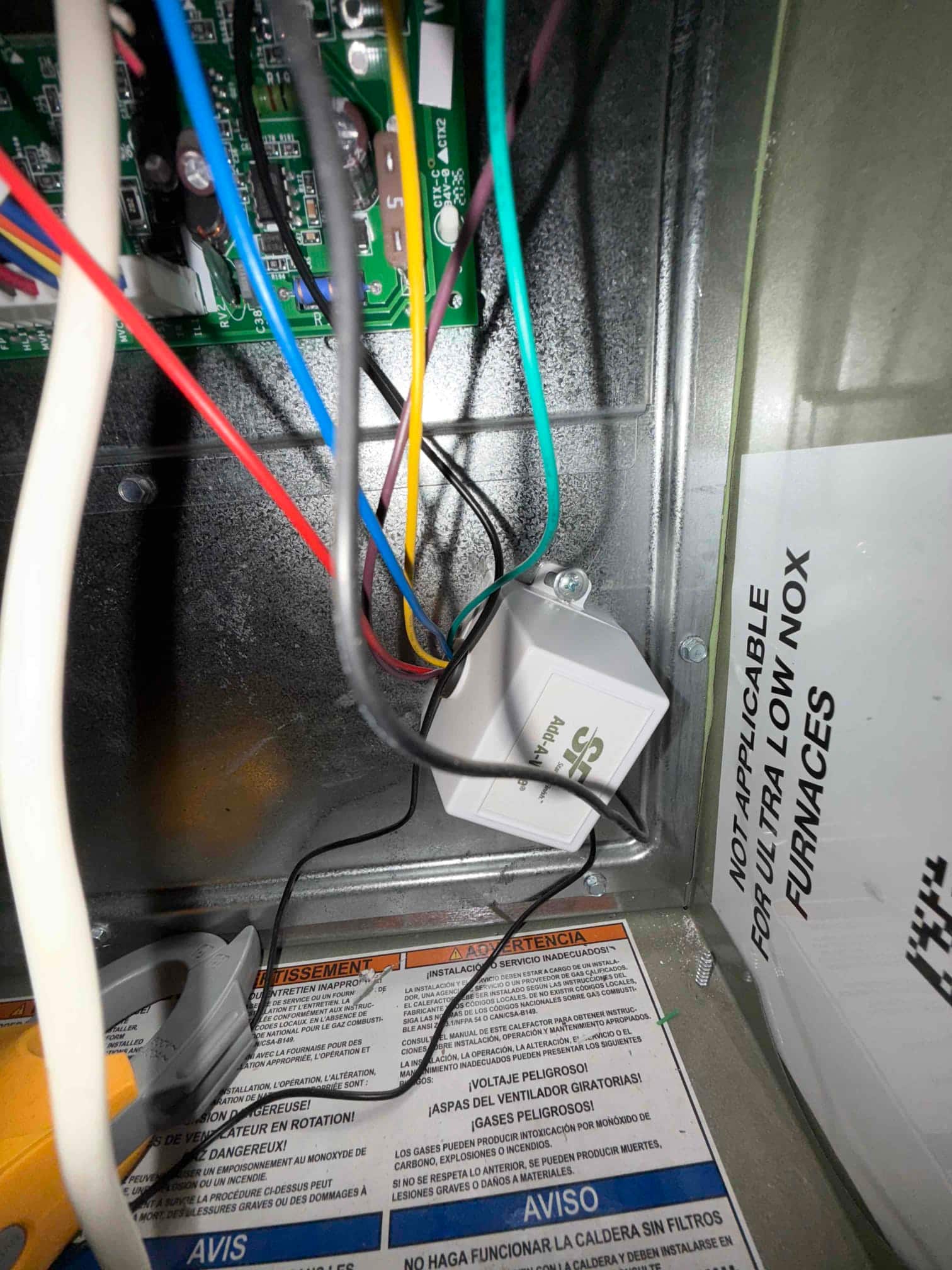 Add-a-wire module installed inside the air handler control compartment with connected low-voltage wiring visible.