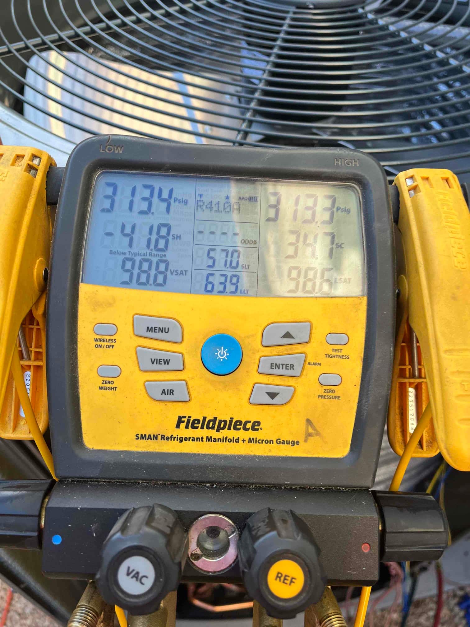 Digital manifold gauges show equal pressure around 313 PSI on both sides during a nitrogen pressure test at the outdoor unit.