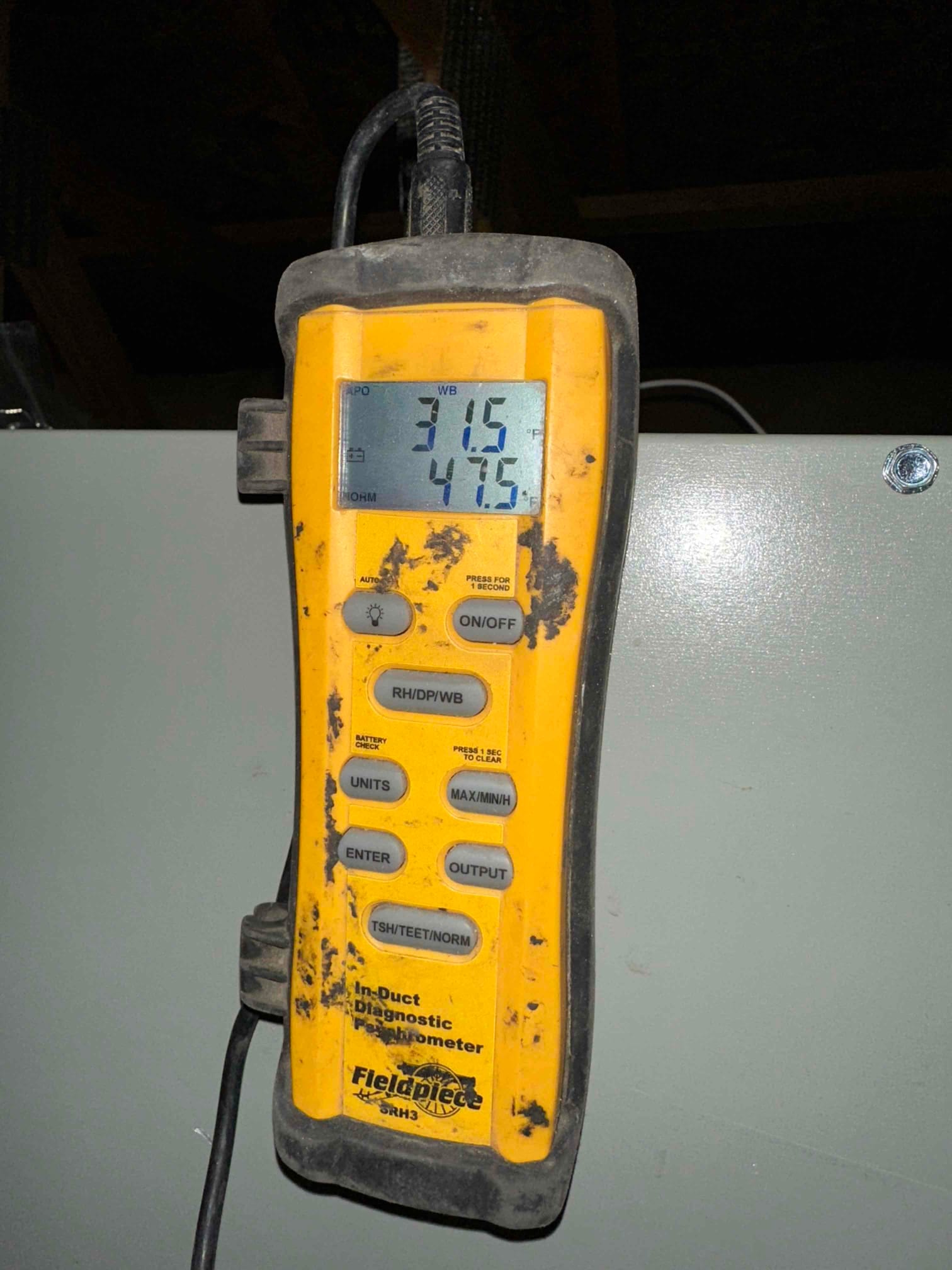 Digital psychrometer displays 31.5 and 47.5 degrees Fahrenheit during air-side testing at the new HVAC installation.