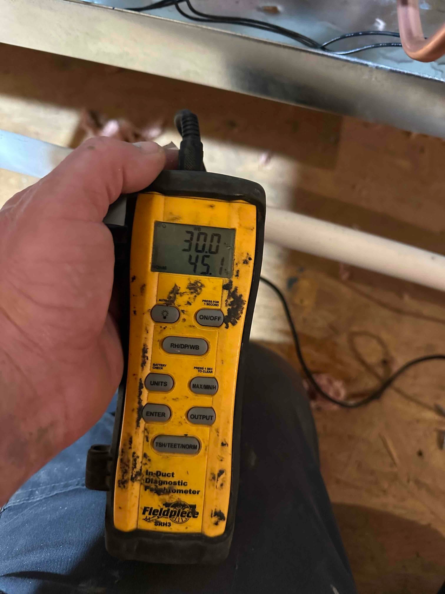 Handheld digital thermometer with probe displays 45.1 degrees Fahrenheit during supply air temperature check at the duct.