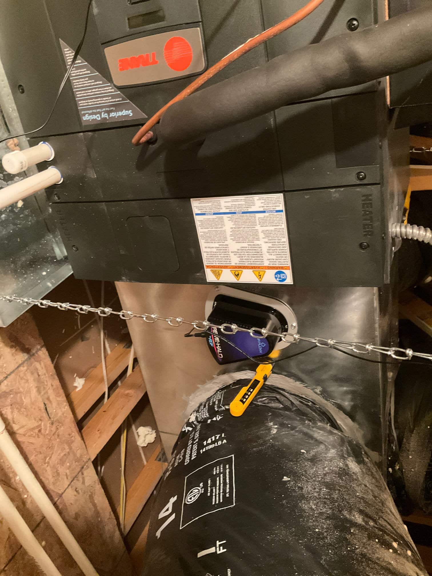 New air handler connected to insulated flex duct with sealed transition and supported by hanging chain in the attic space.