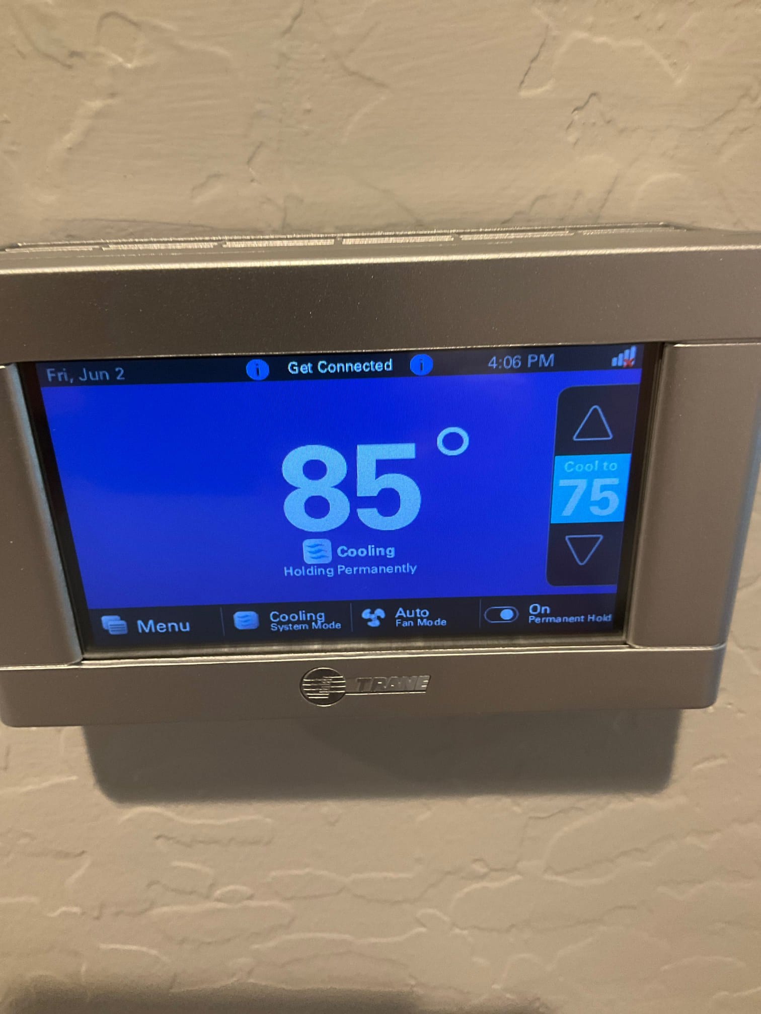 Wall-mounted touchscreen thermostat displays 85 degrees and shows cooling mode active with a setpoint of 75.