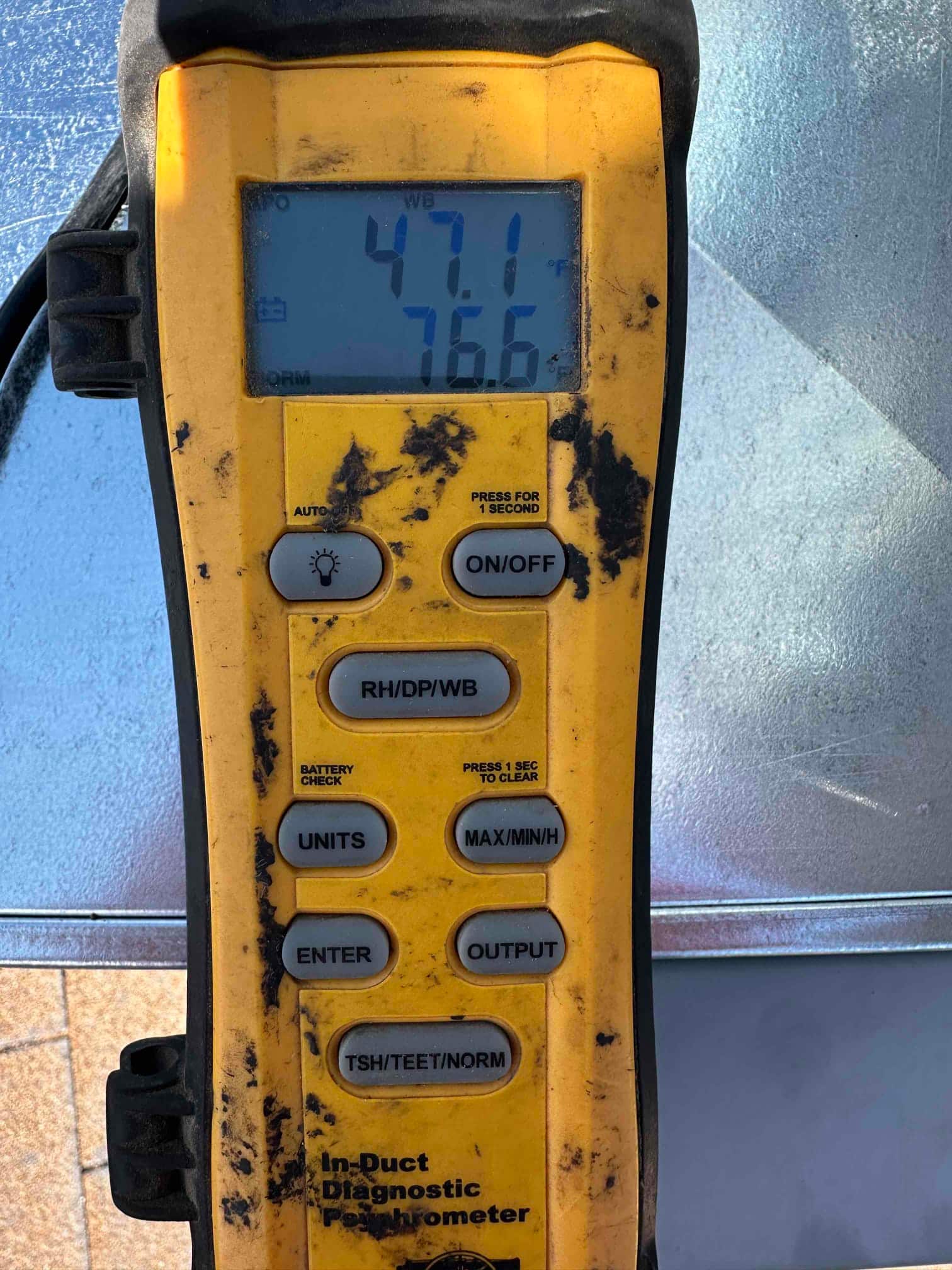Digital psychrometer shows air temperatures of 47.1°F and 76.6°F during supply and return air checks on the new system.