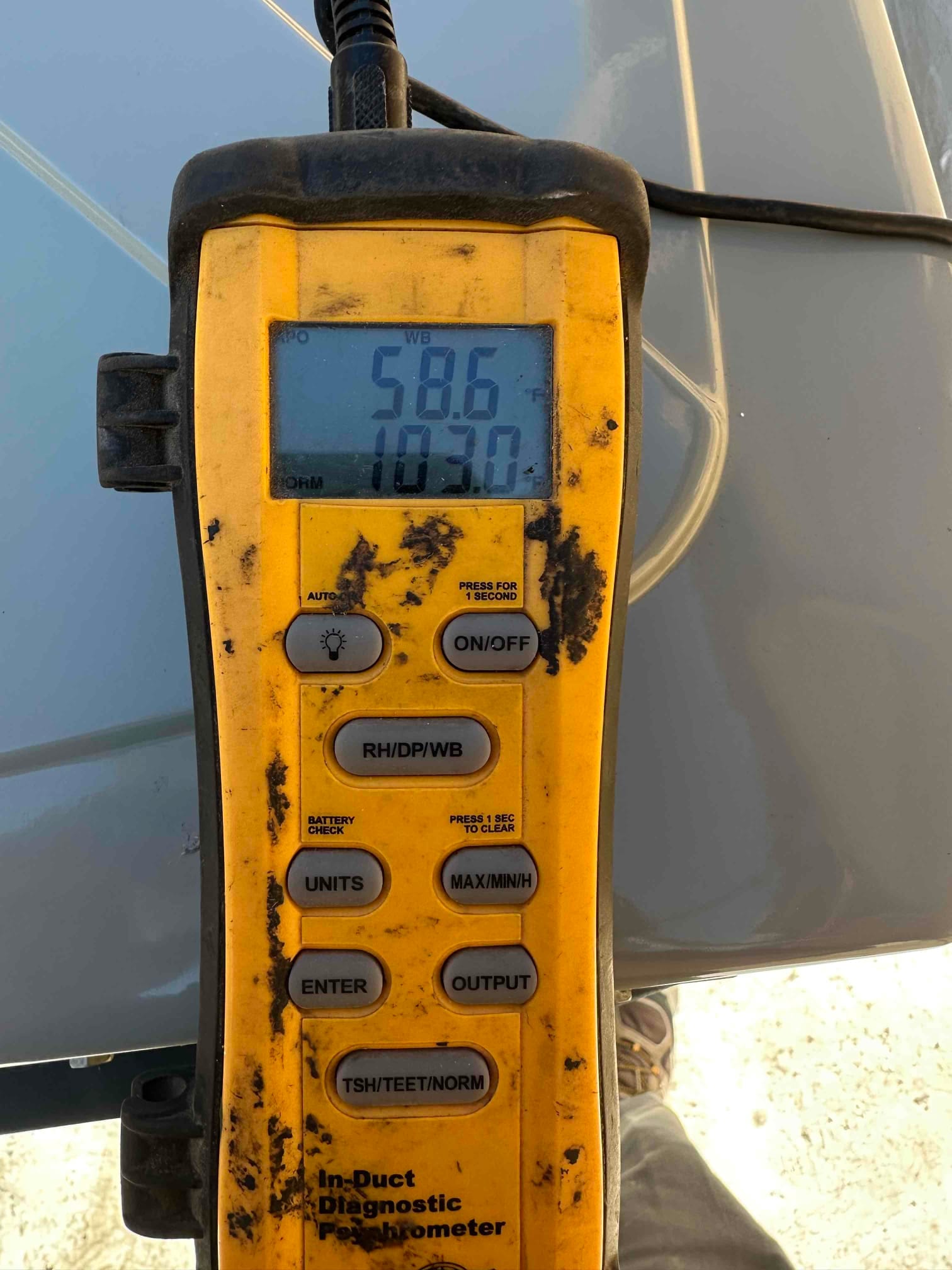 Digital thermometer shows 58.6 degrees, documenting supply air temperature during system commissioning.