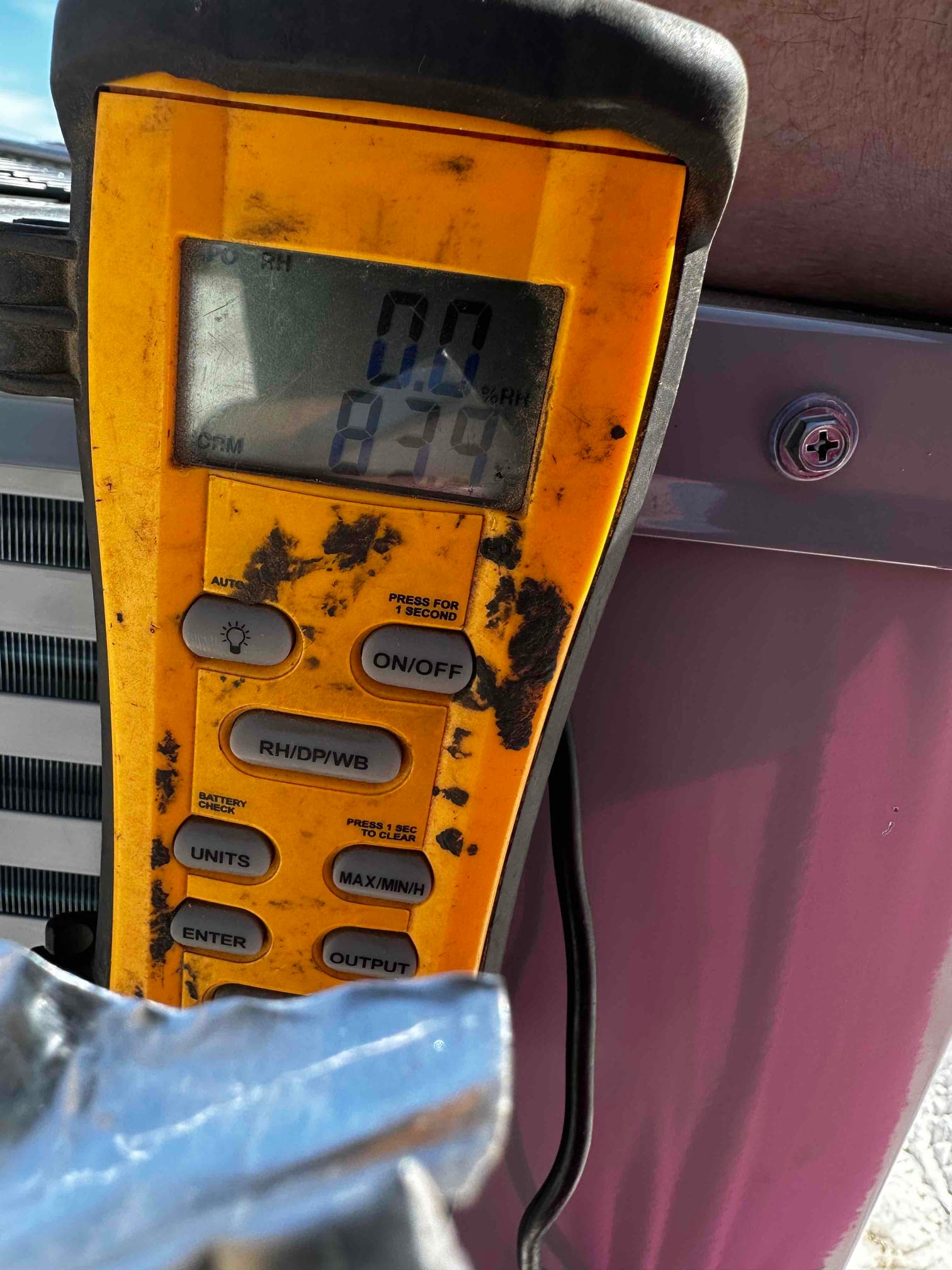 Handheld meter displays 83°F air temperature with 0.0% RH reading during HVAC system air-side check.