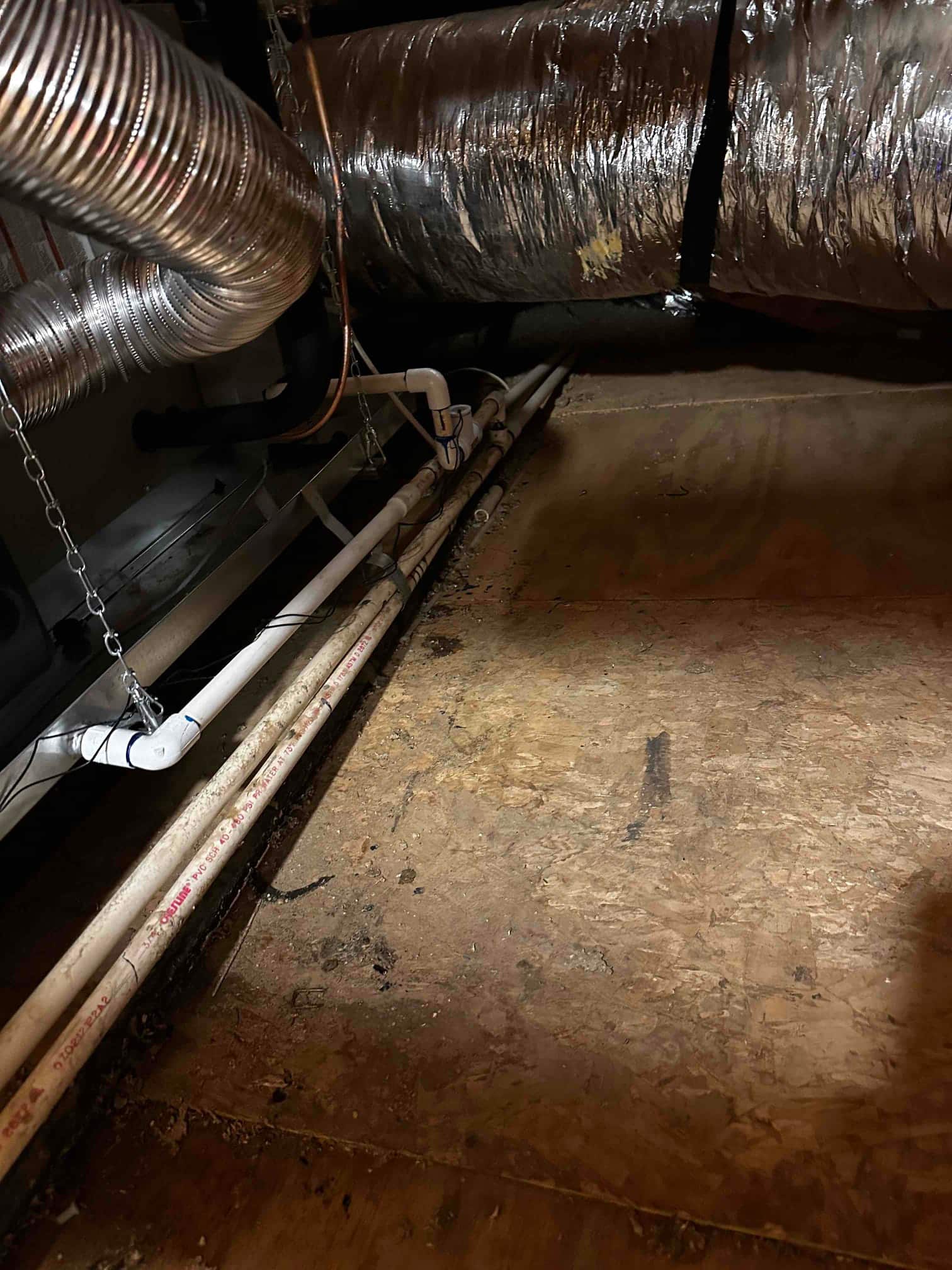 Attic air handler with insulated flex duct, metal vent connections, and newly run PVC condensate drain piping secured and sloped.