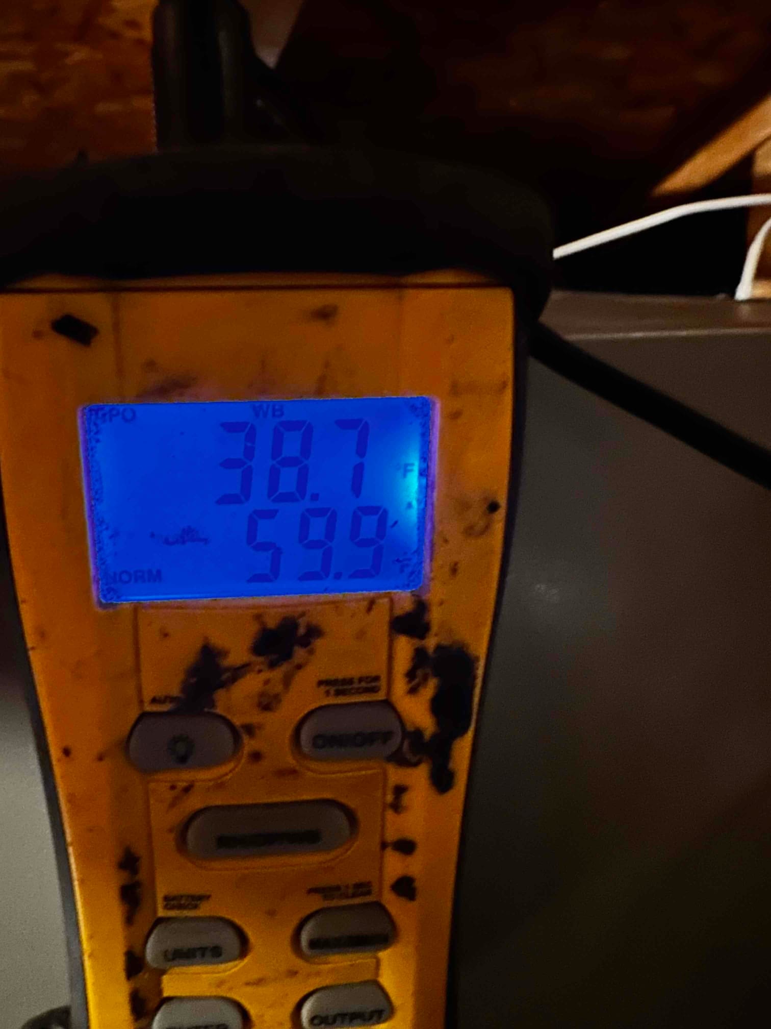 Digital thermometer displays 59.9°F air temperature during commissioning, indicating supply air leaving the evaporator.