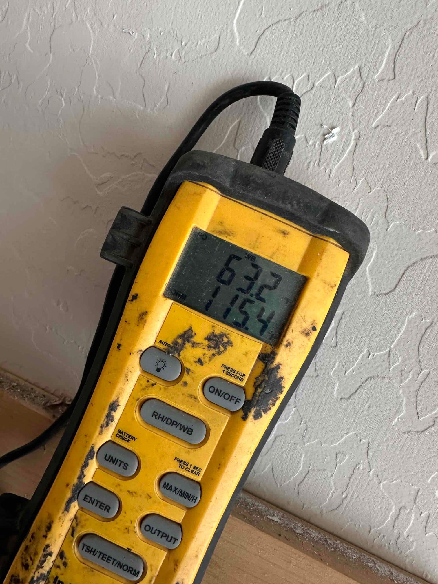 Digital thermometer displays 63.2 and 71.54 degrees, documenting air temperature readings during system commissioning.
