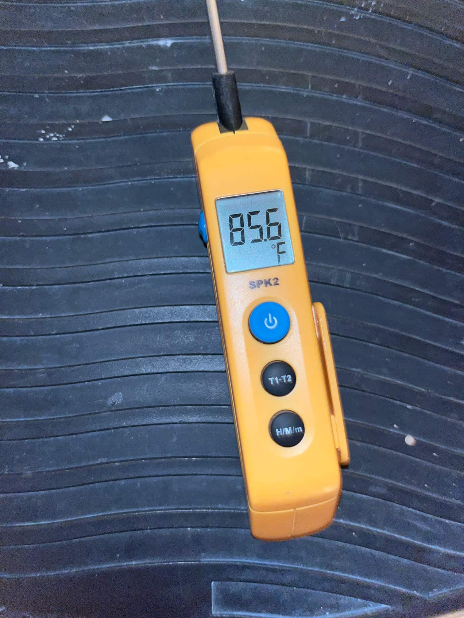 Digital thermometer displays 85.6 °F with probe attached, showing the measured temperature during the air conditioning repair.