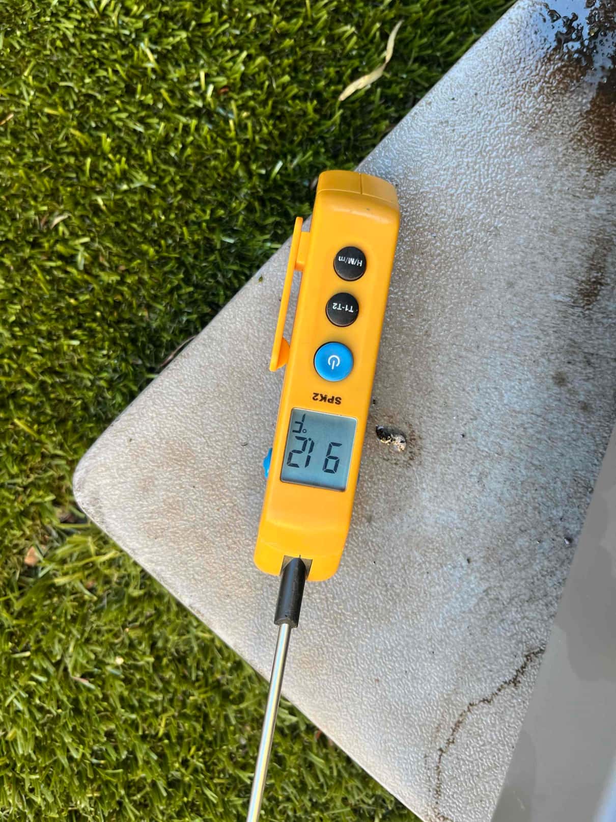 Digital thermometer with probe shows 21.6 °C on its display during temperature measurement at the repair site.