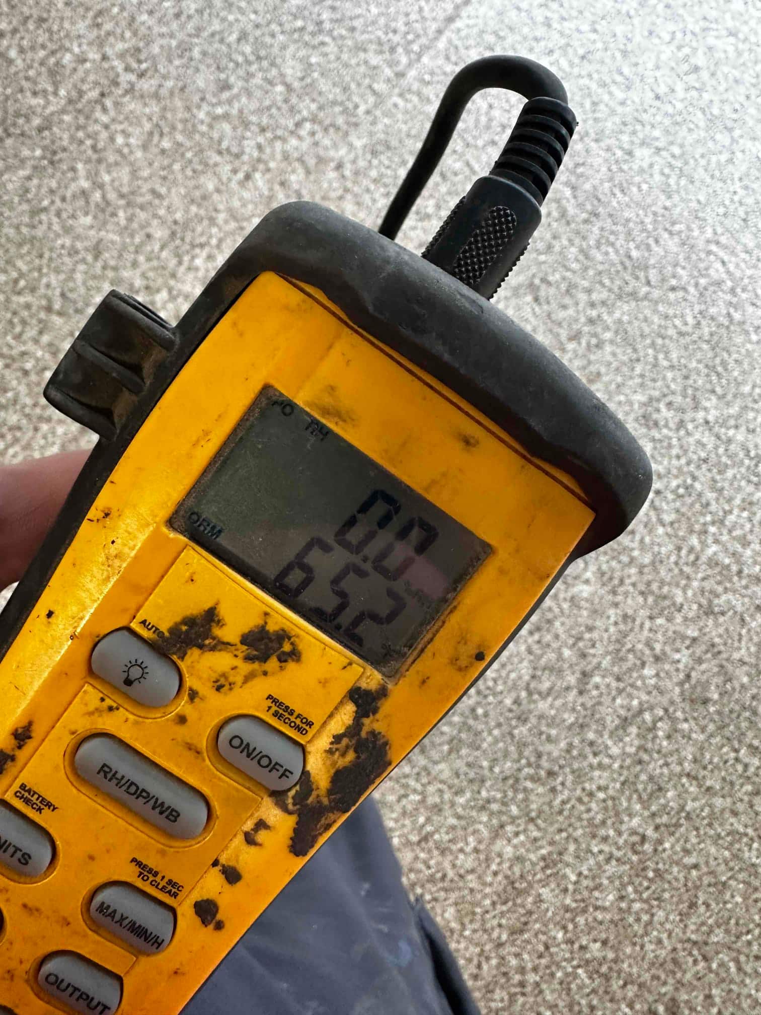 Digital thermometer shows a 65.2 degree Fahrenheit reading during air temperature check on the new mini‑split installation.
