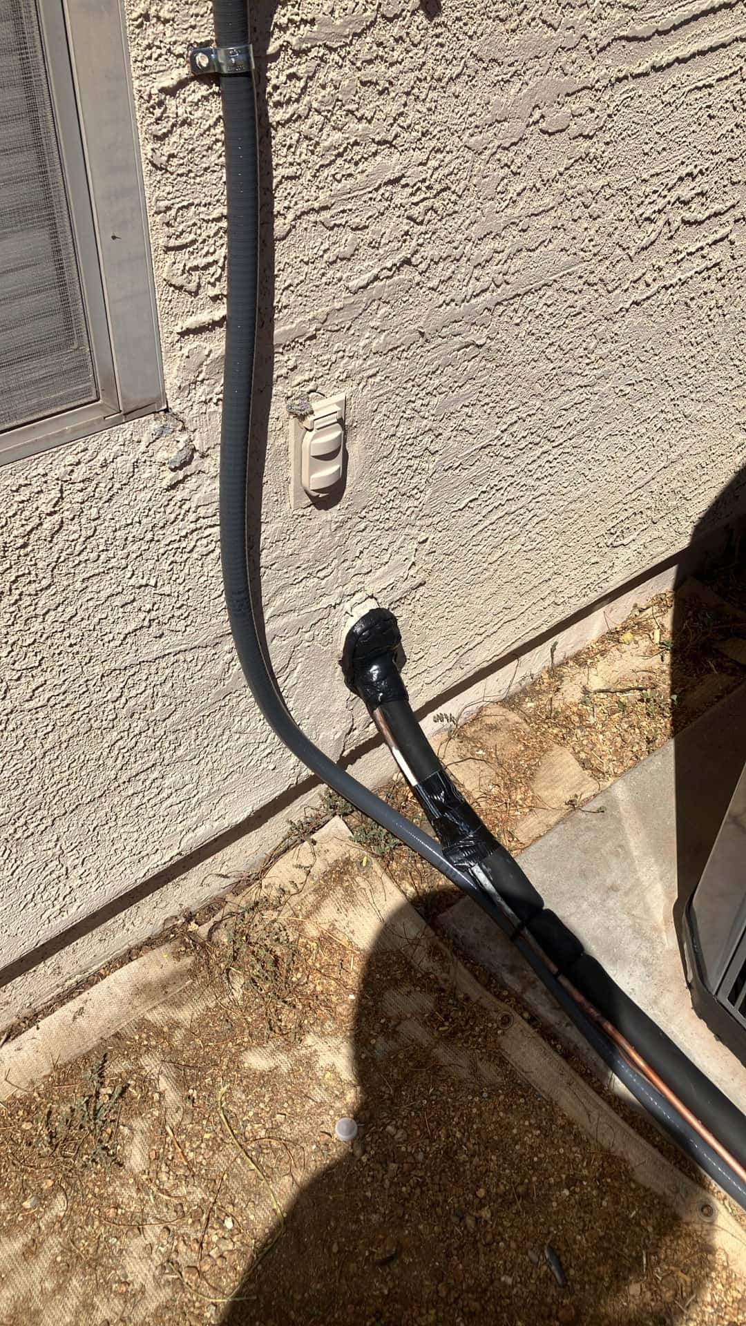 Insulated refrigerant line set and electrical whip secured along exterior wall with sealed wall penetration beside the new outdoor unit.