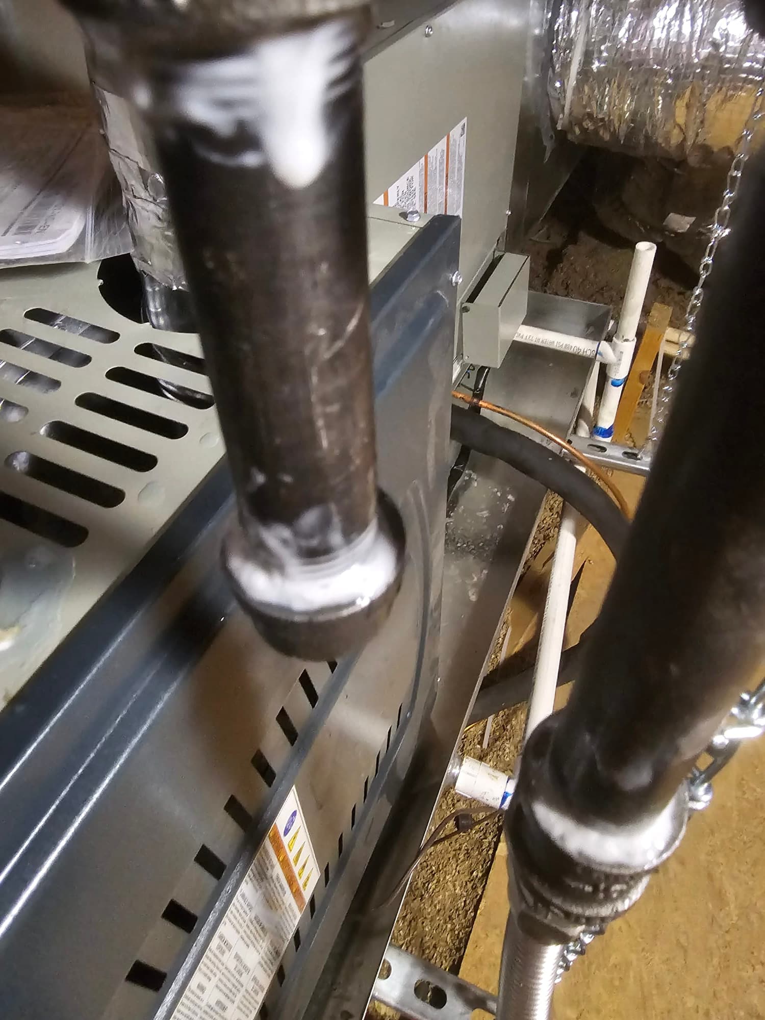 New indoor HVAC unit installed with connected gas piping, condensate drain, flexible conduit, and sealed duct connections in the attic.