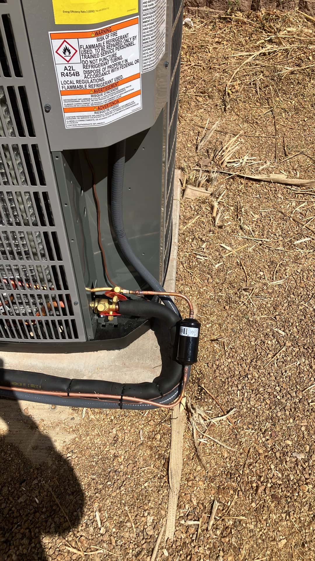 Outdoor condenser connections with insulated suction line, liquid line filter-drier, and service valves neatly brazed and routed on new installation.