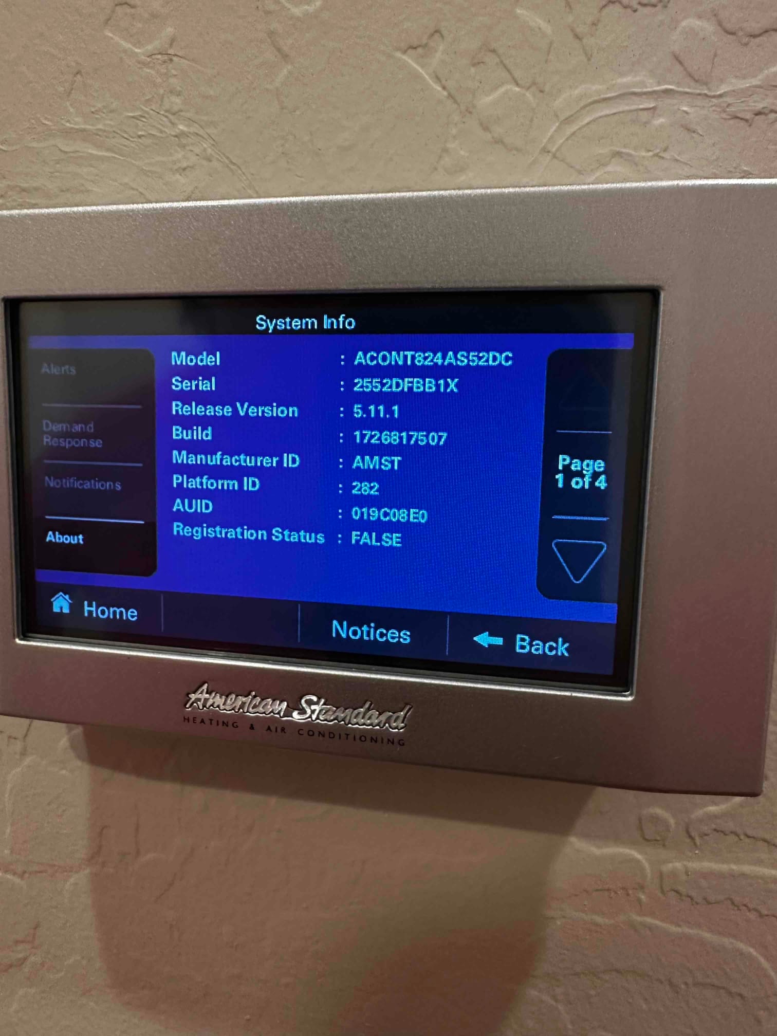 Wall-mounted thermostat displaying system information screen during setup after new air conditioning installation.